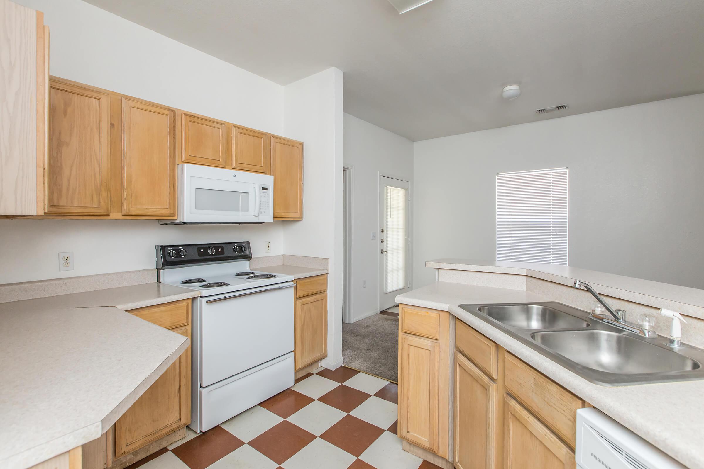 a kitchen with white appliances and wooden cabinets