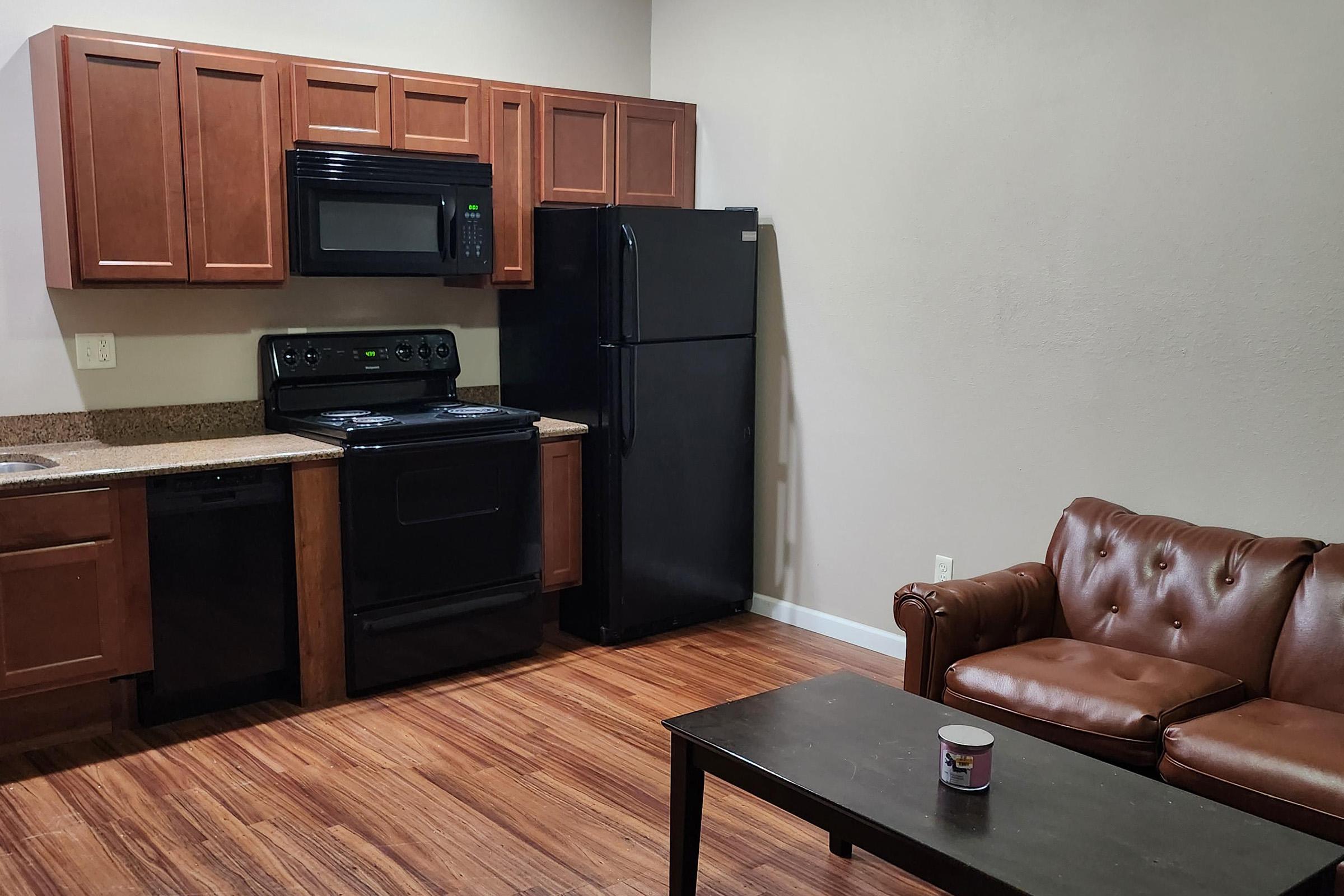a kitchen with wooden cabinets and a brown couch