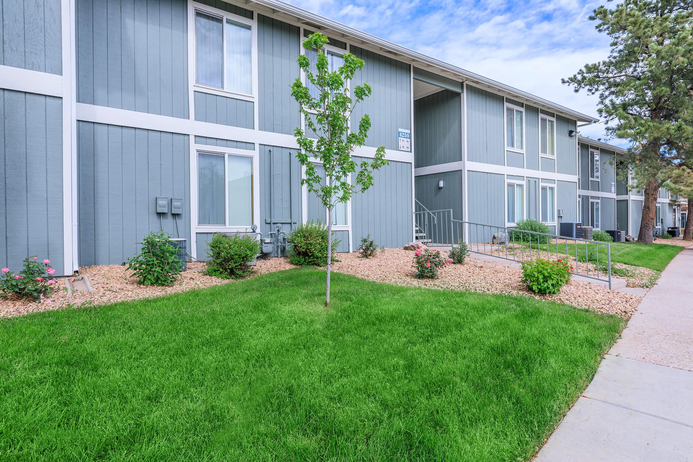 a large brick building with grass in front of a house