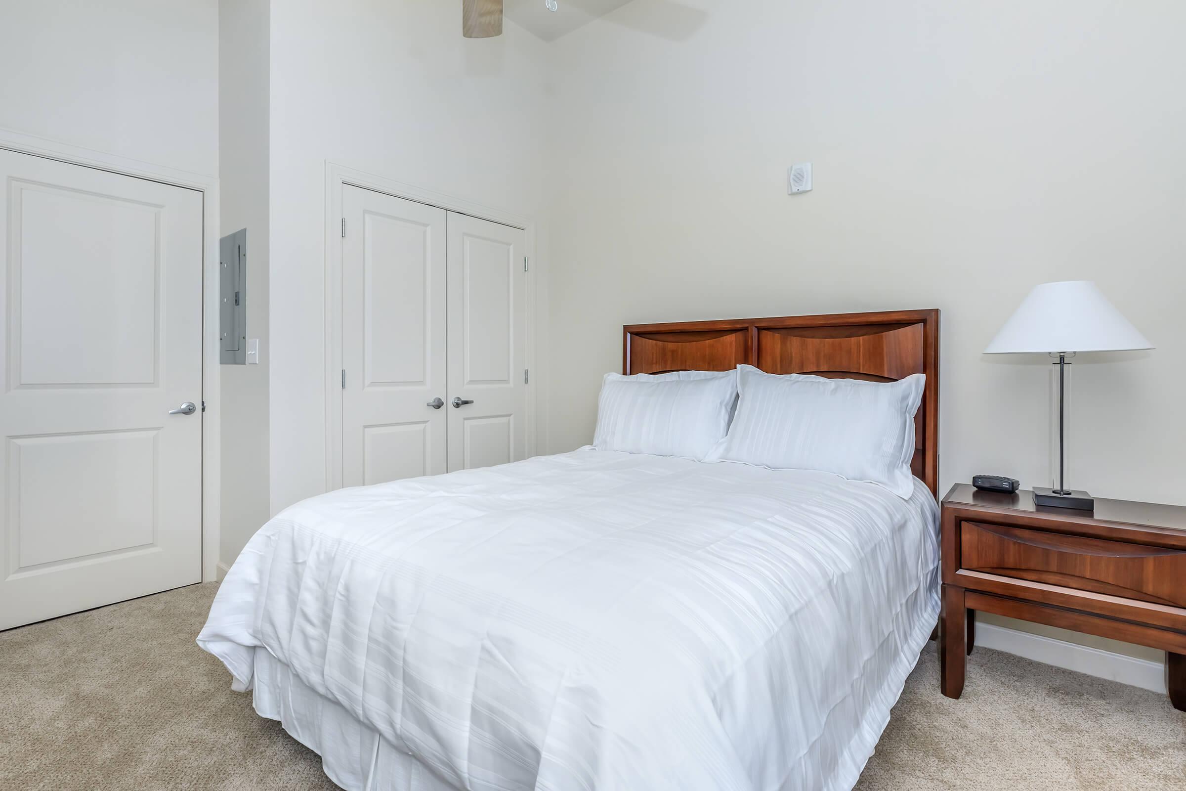 a bedroom with a bed and desk in a hotel room