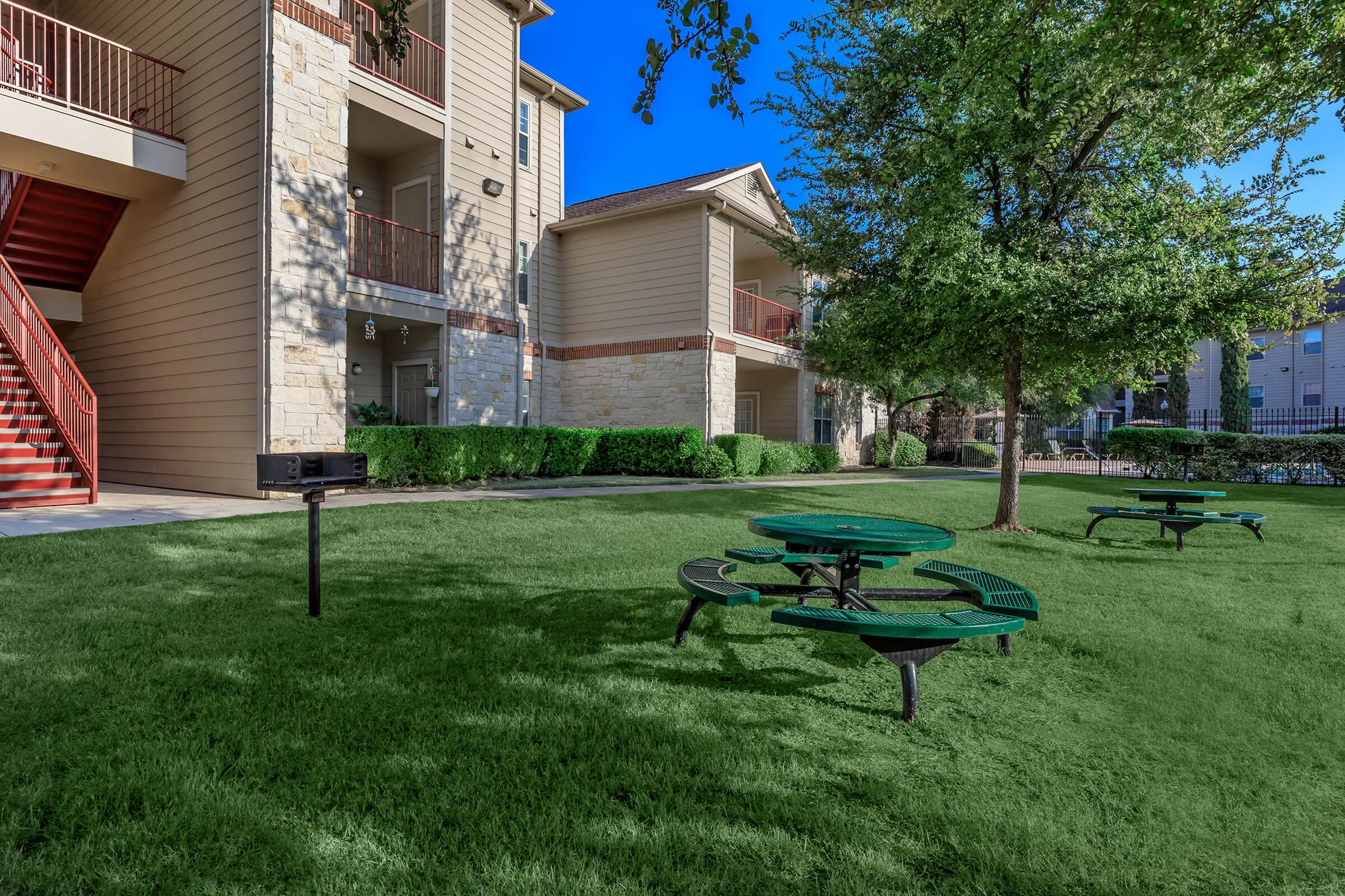 a group of lawn chairs sitting on a bench in front of a house