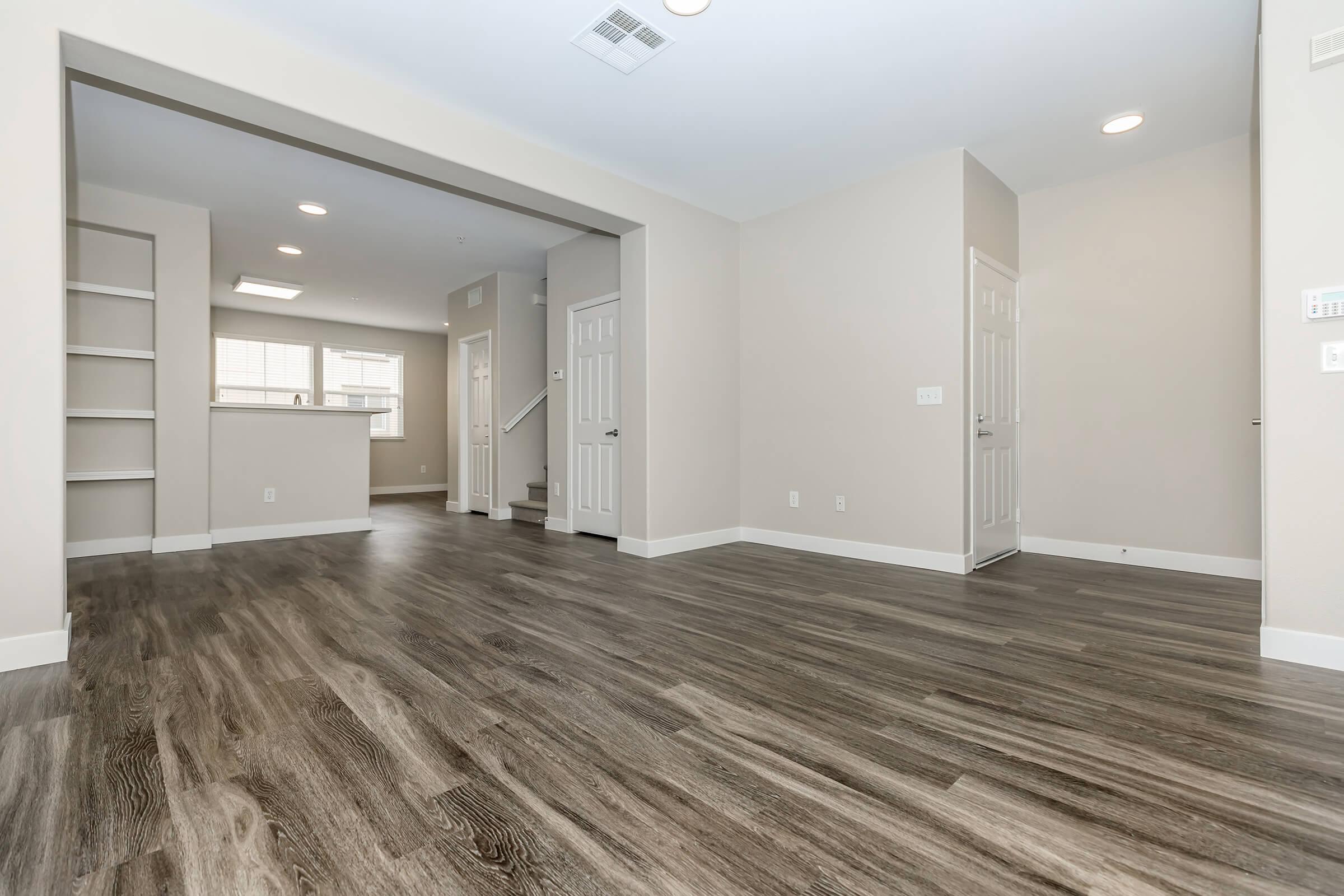 Unfurnished living room and dining room with wooden floors