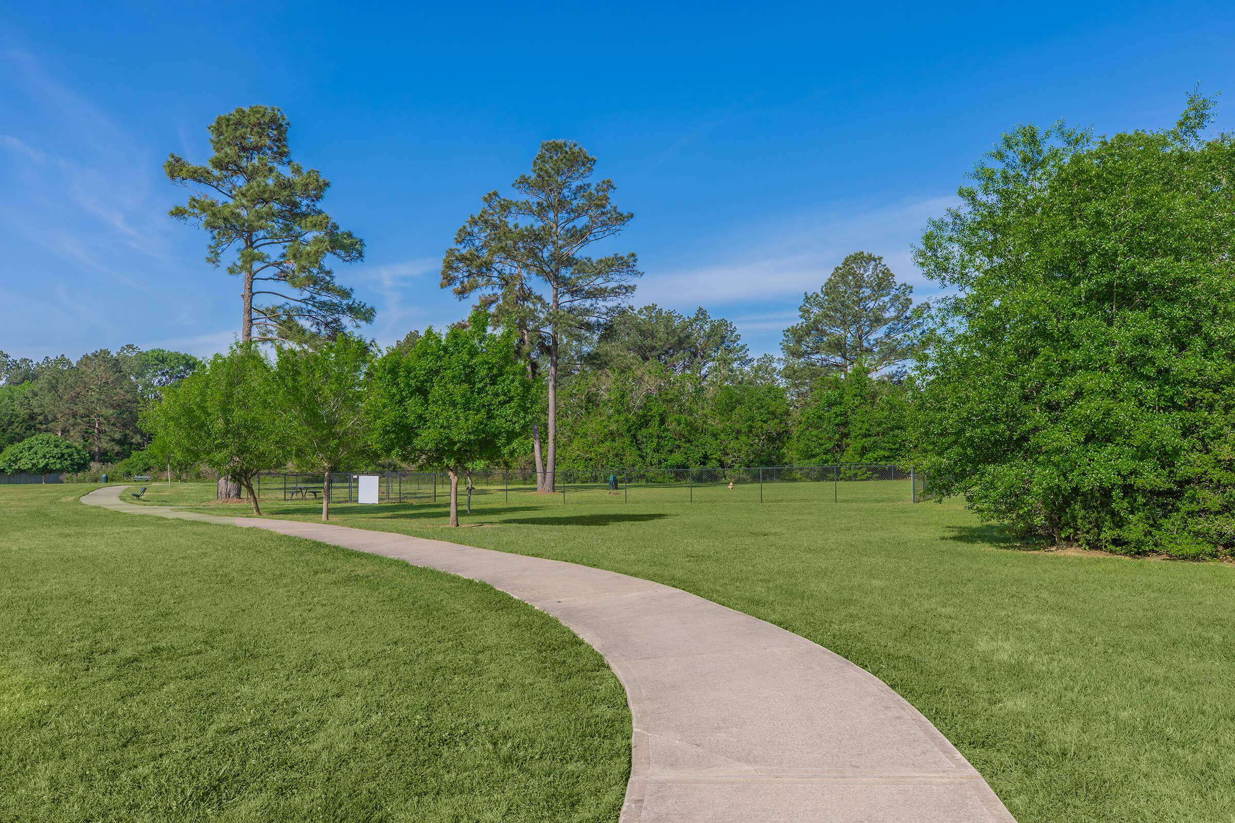 a large green field with trees in the background