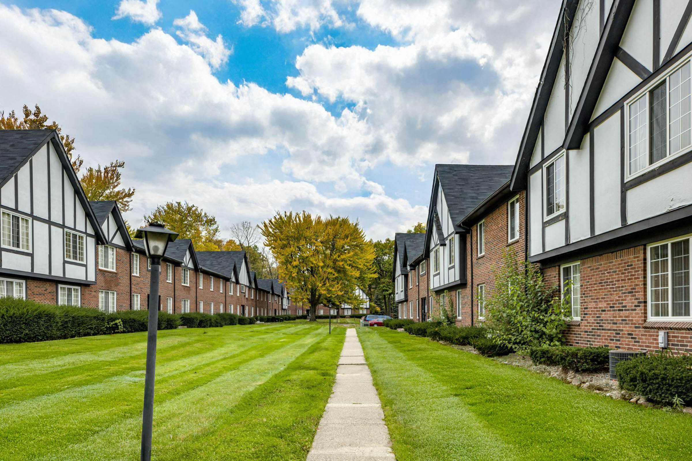 a large brick building with grass in front of a house