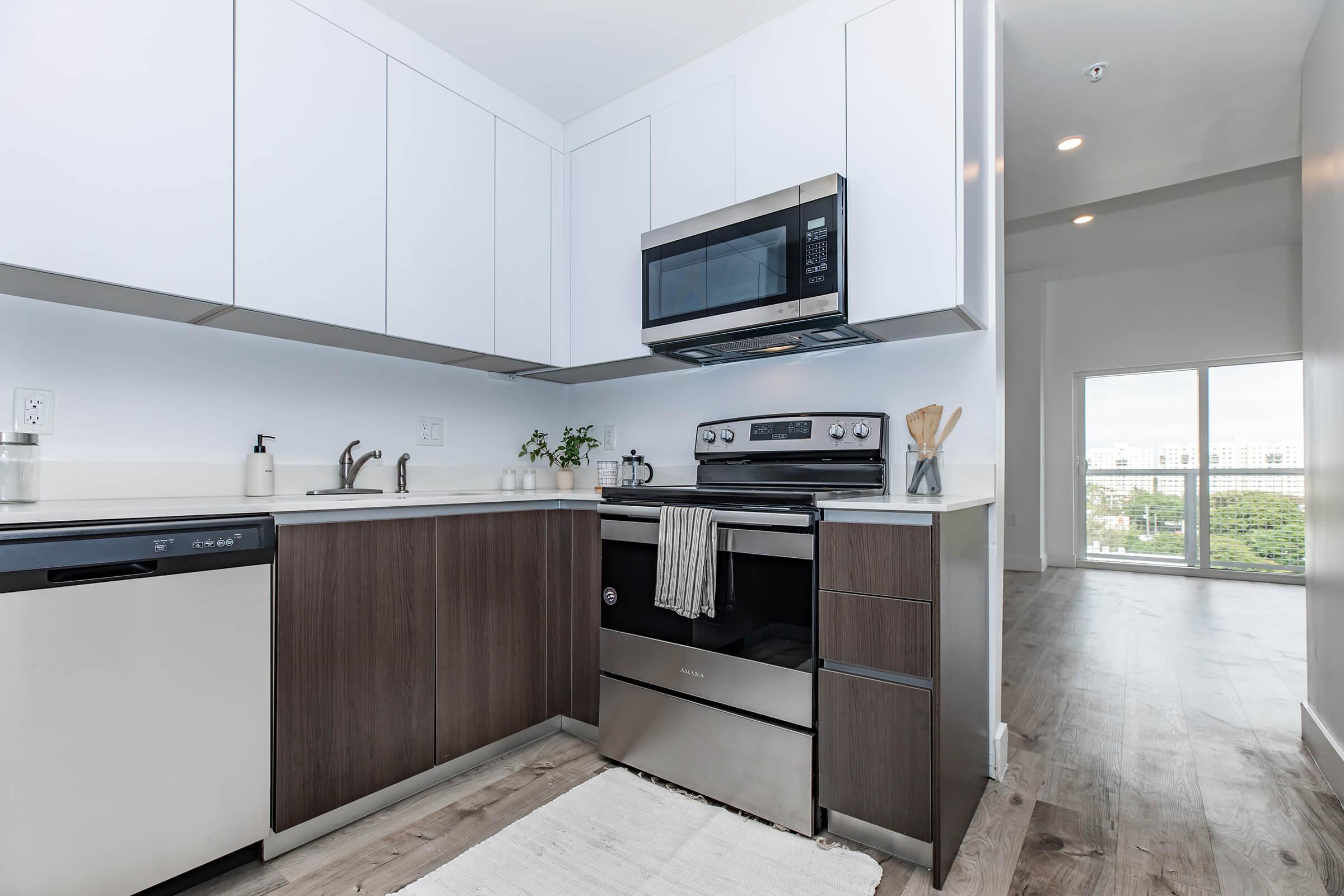 Kitchen with brown lower cabinets and white upper cabinets, stainless kitchen appliances