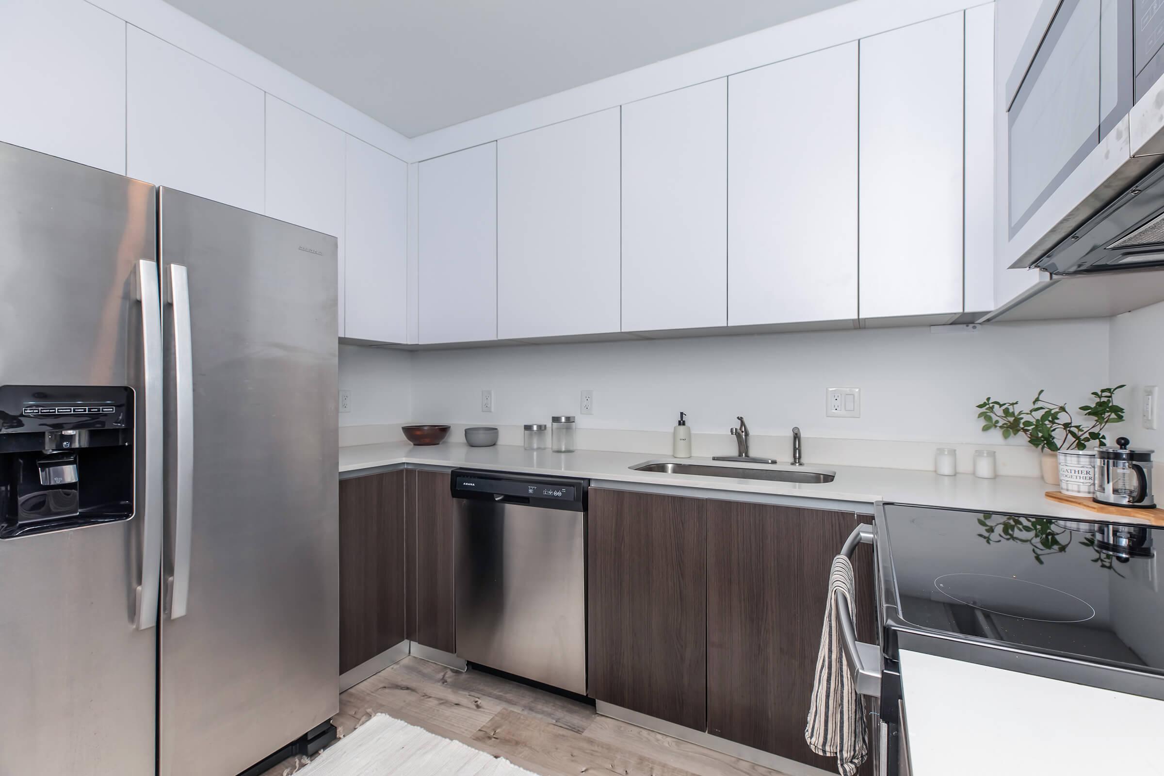 Kitchen with brown lower cabinets and white upper cabinets, stainless kitchen appliances