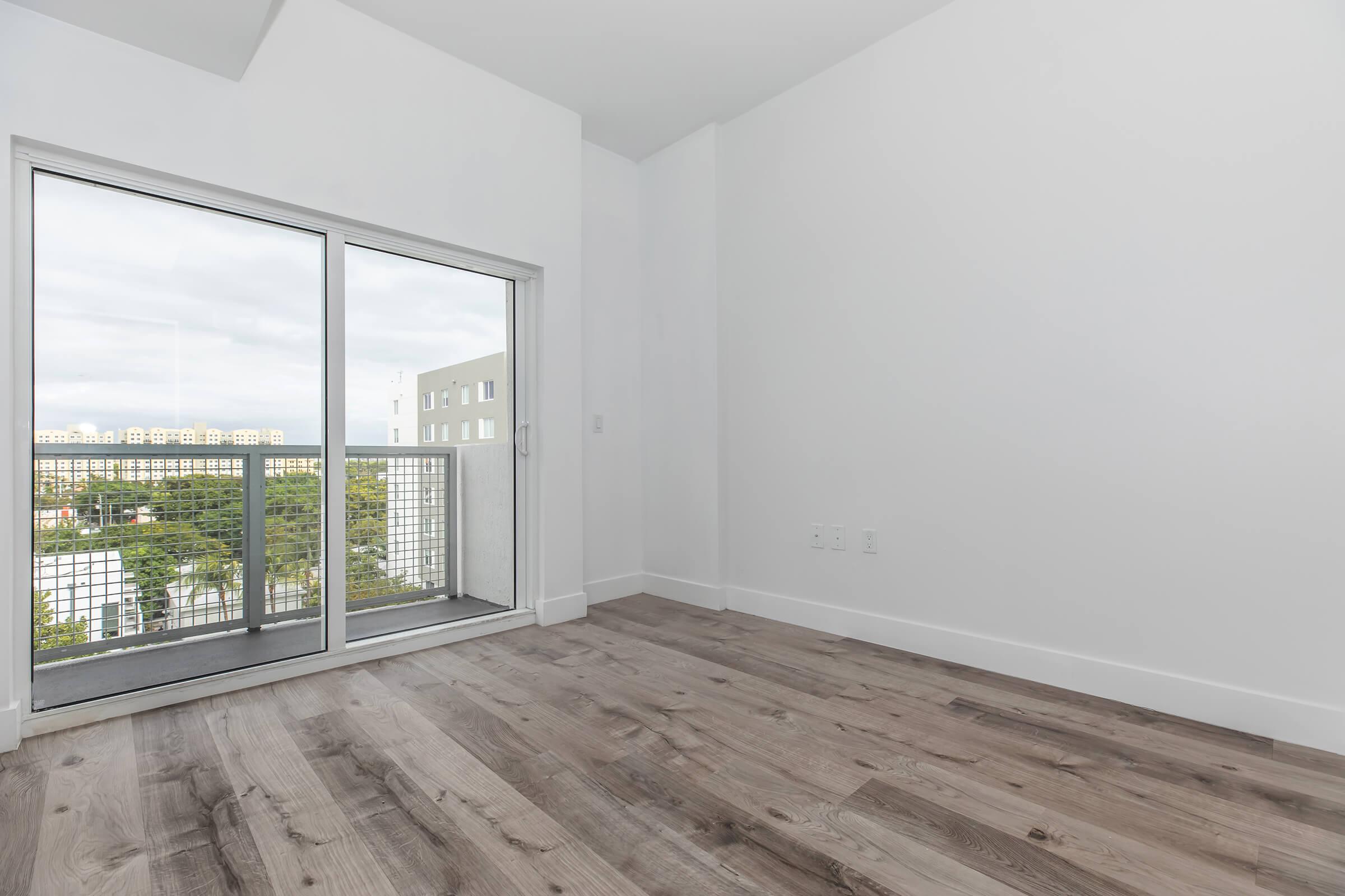 Living room with wood flooring looking to patio