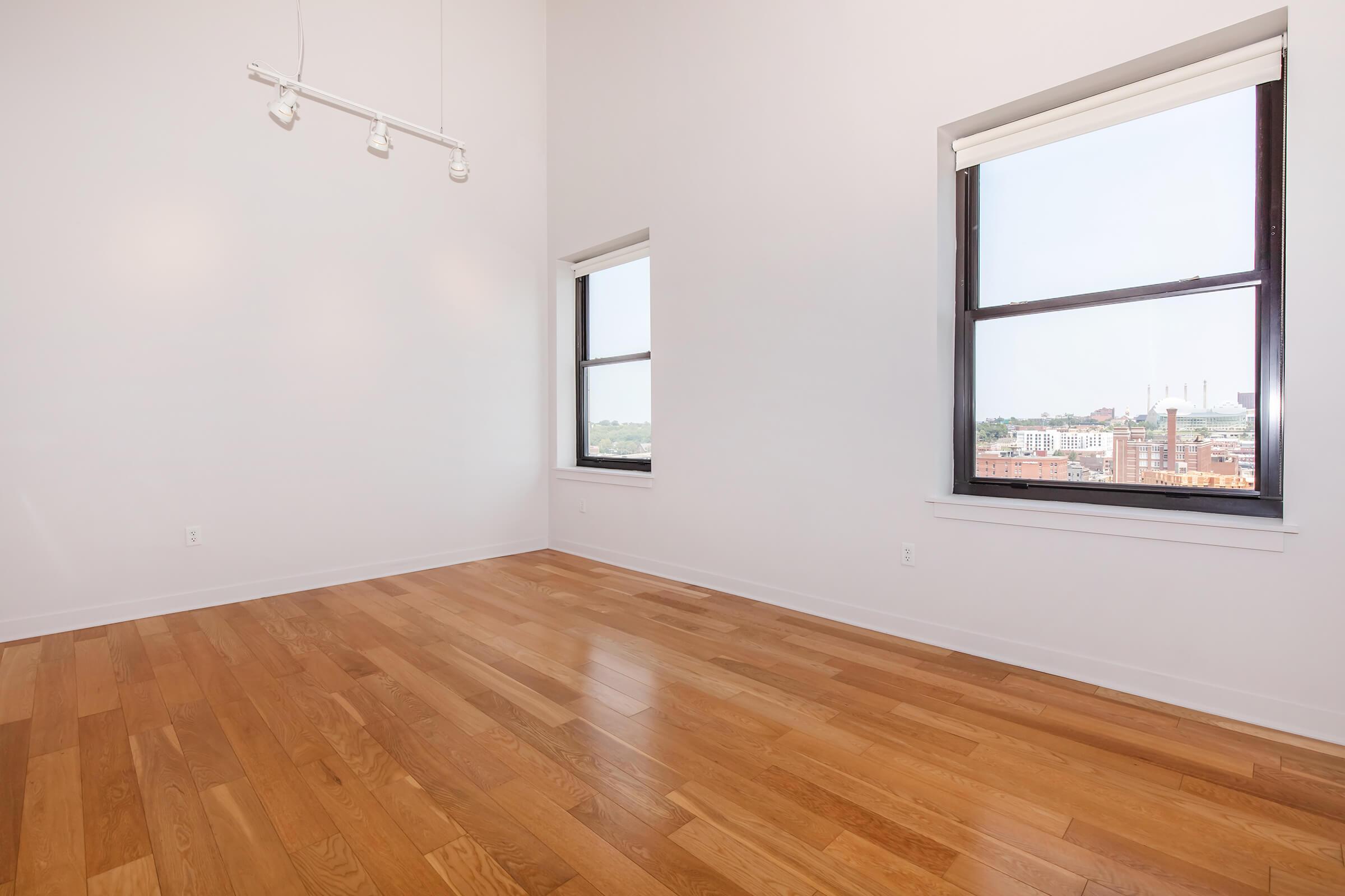 a room with wood floors and a large window