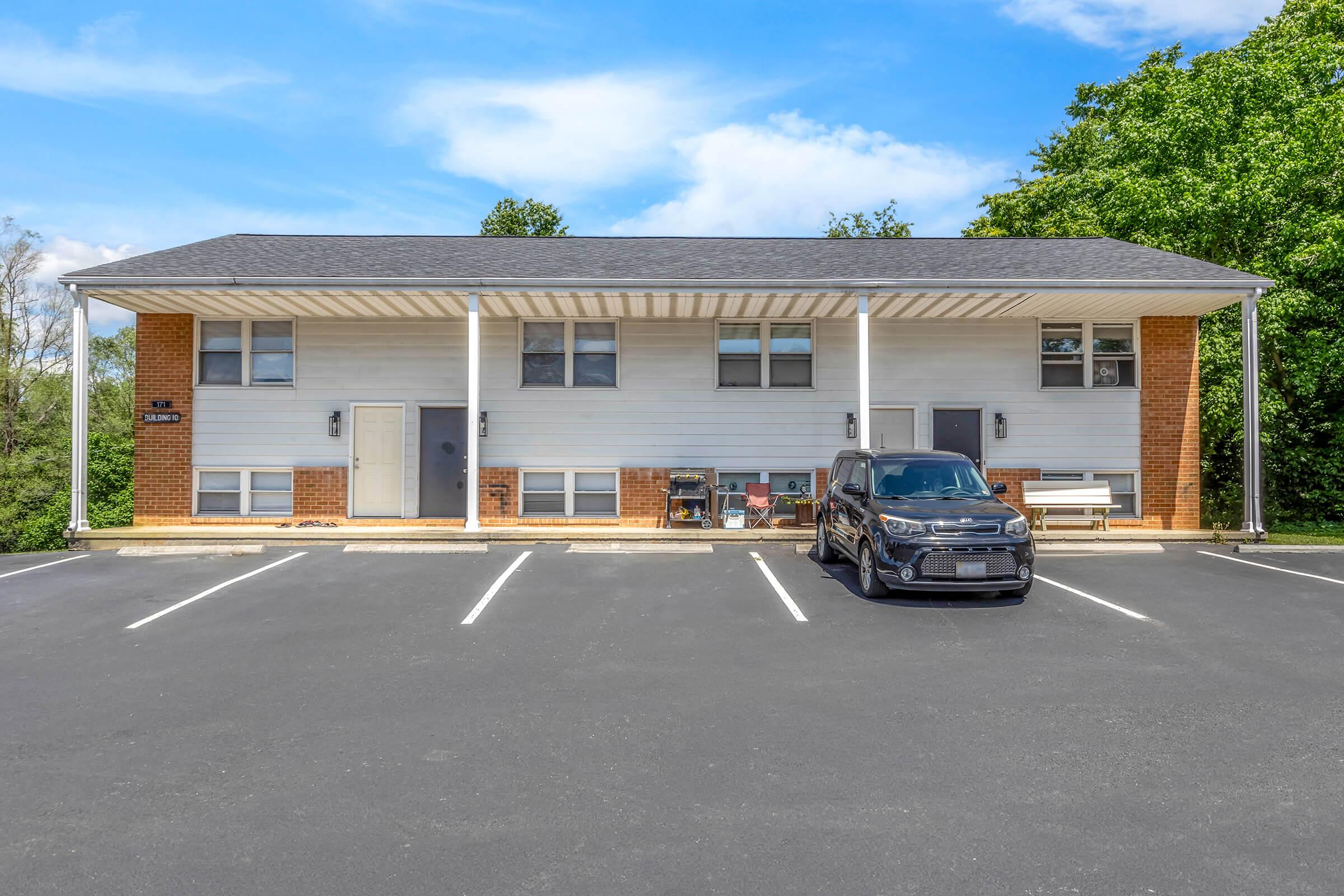 an empty parking lot in front of a house