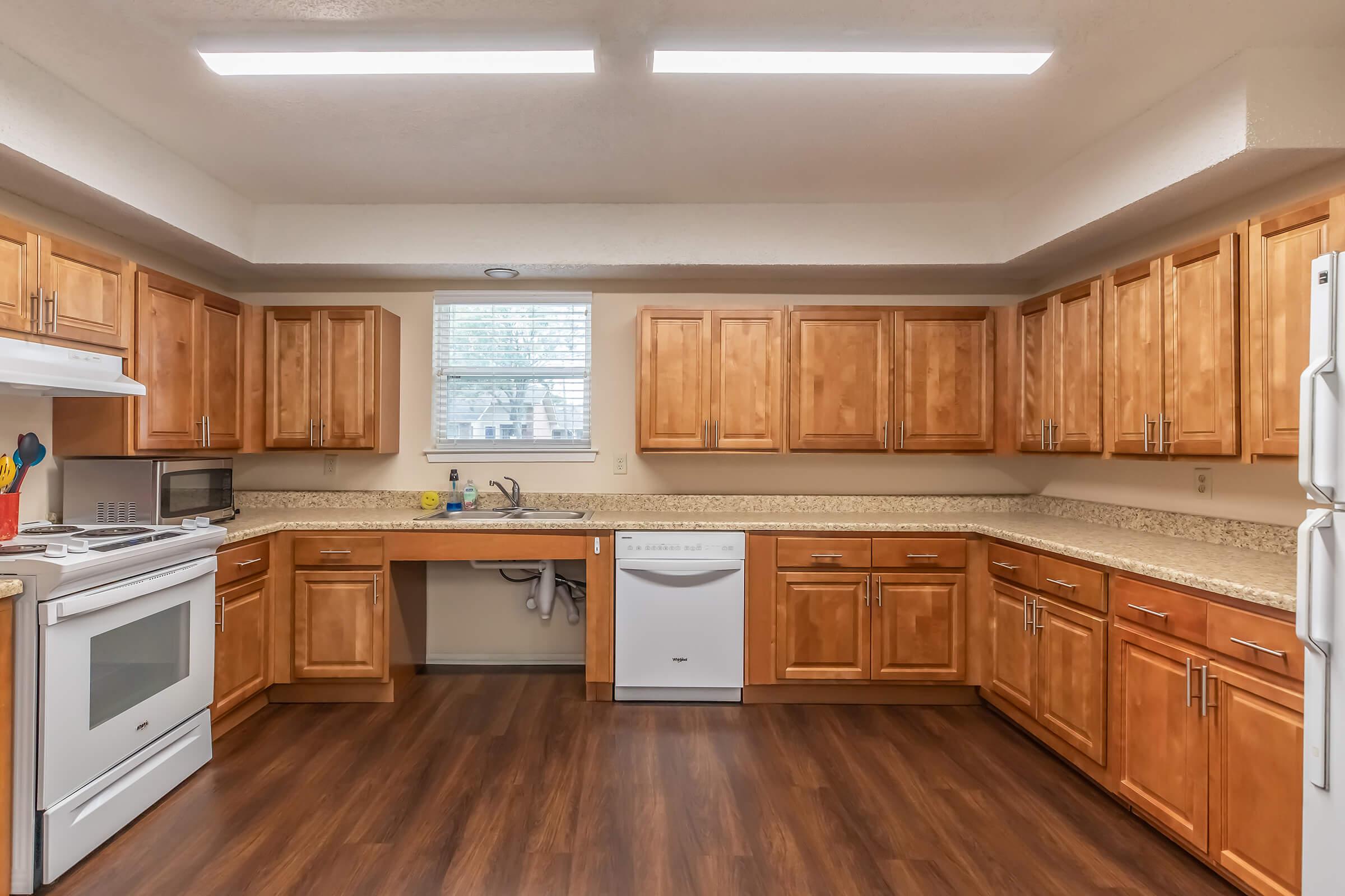 a large kitchen with stainless steel appliances and wooden cabinets