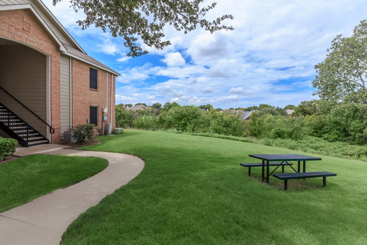 an empty park bench next to a brick building