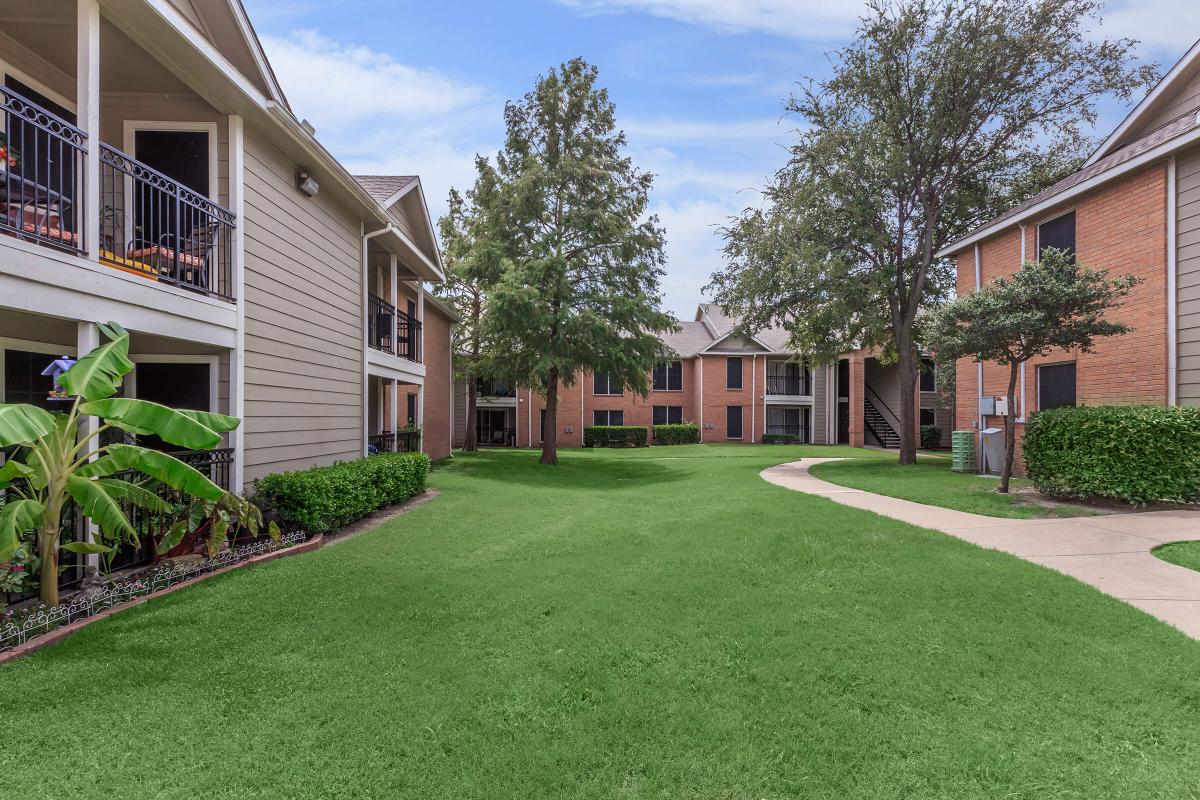 a house with a lawn in front of a brick building