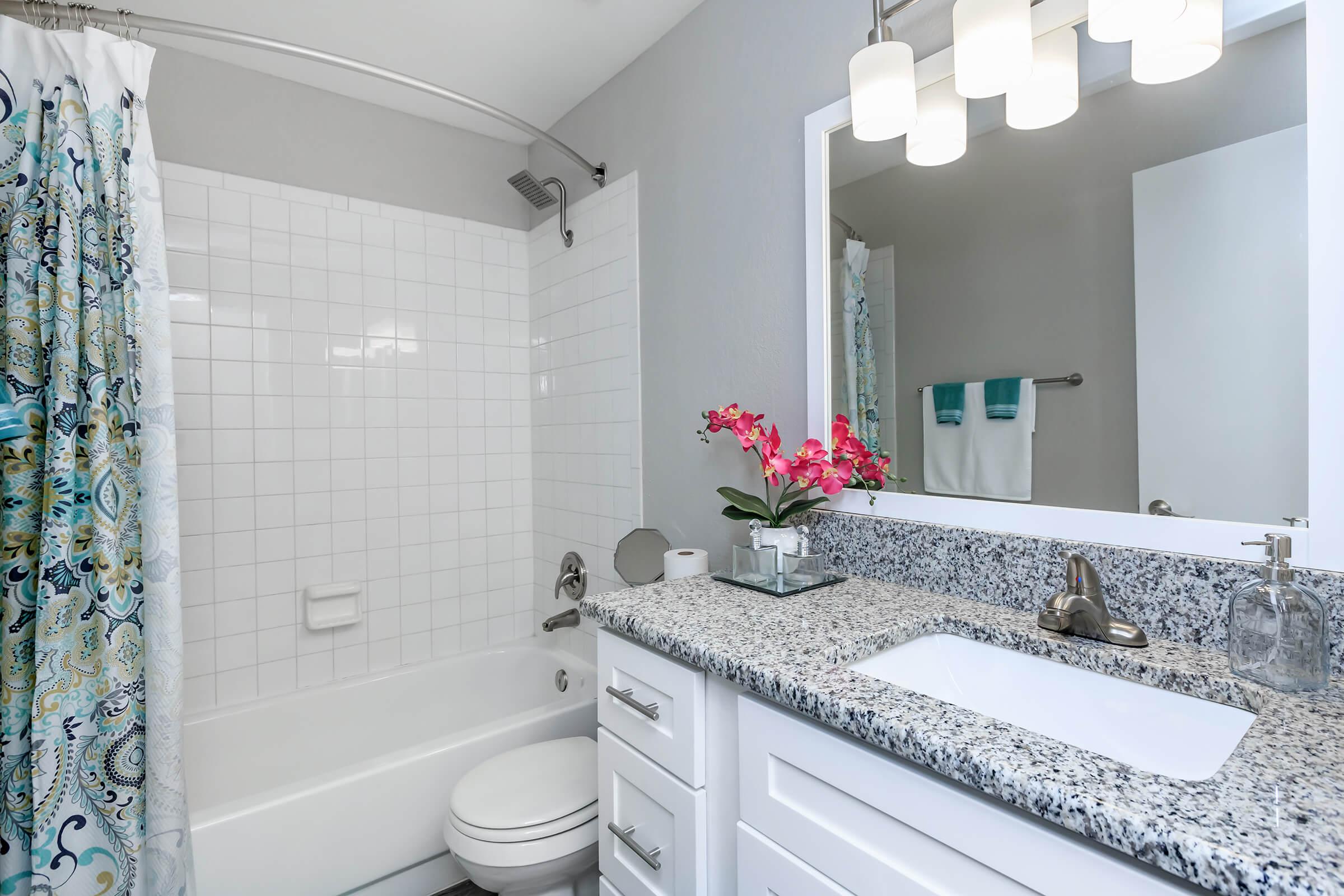 a white sink sitting next to a shower