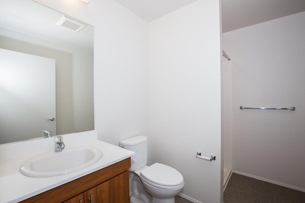 a white sink sitting under a mirror