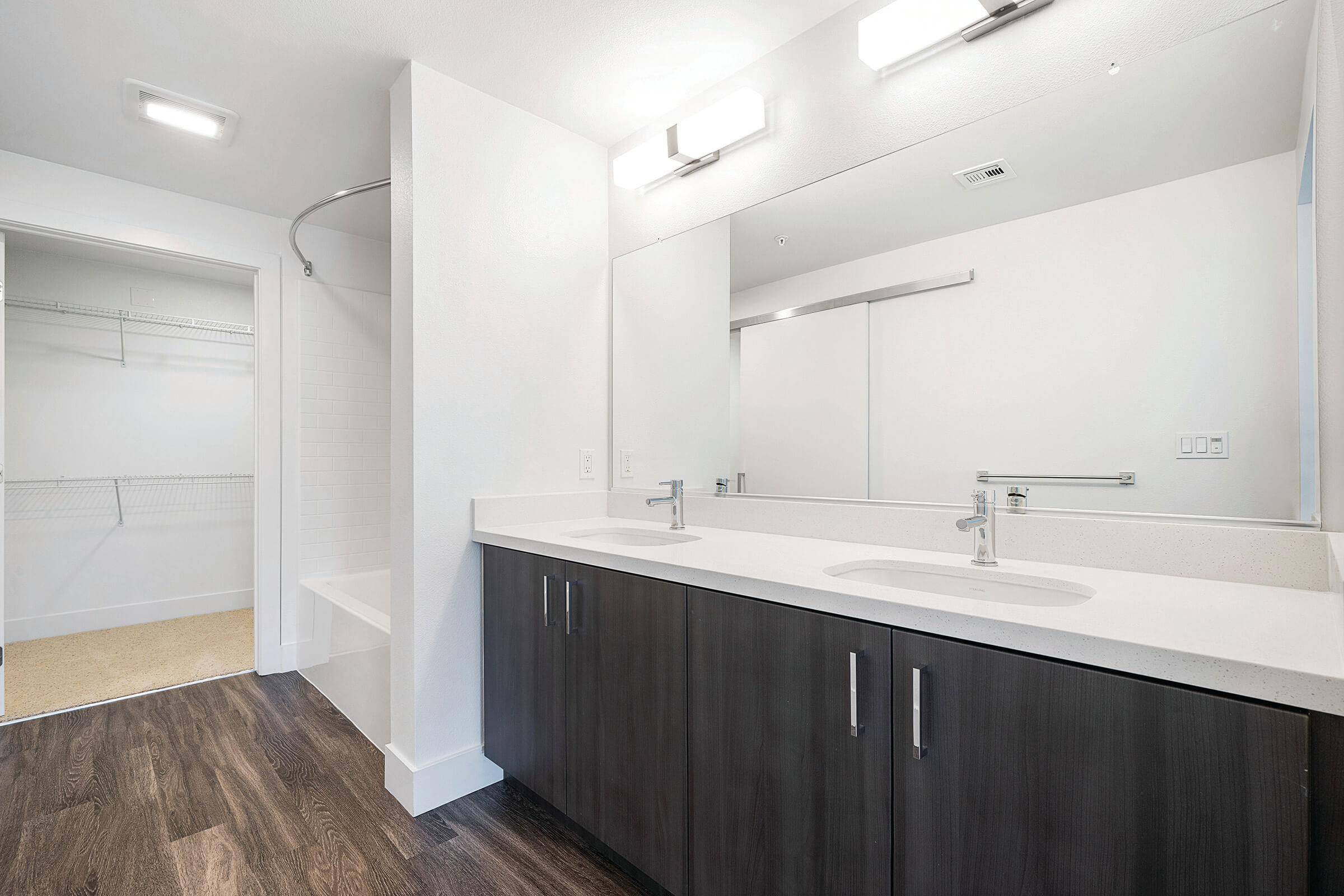 Bathroom sinks with open walk-in closet door
