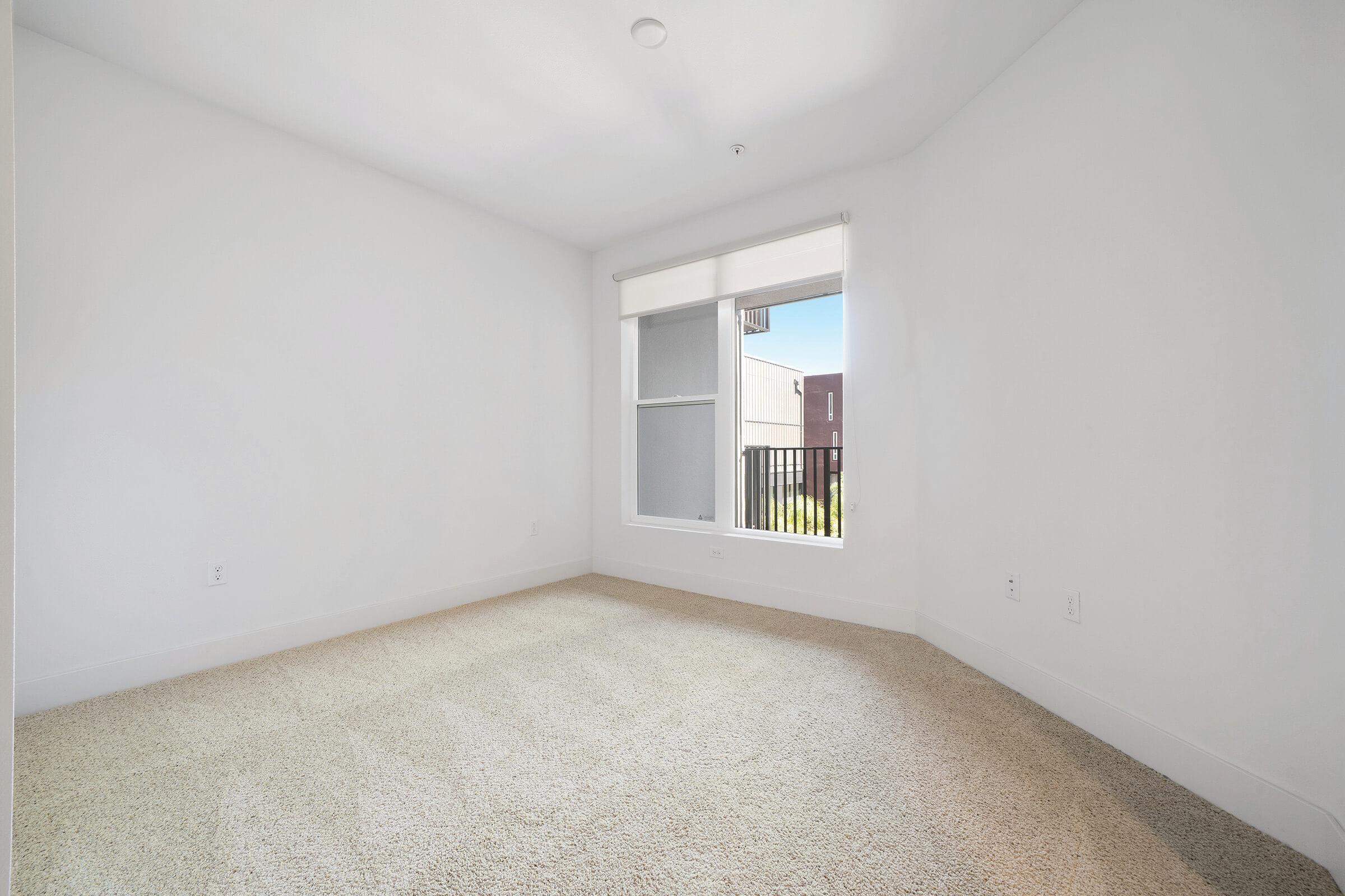 Unfurnished carpeted bedroom with open window