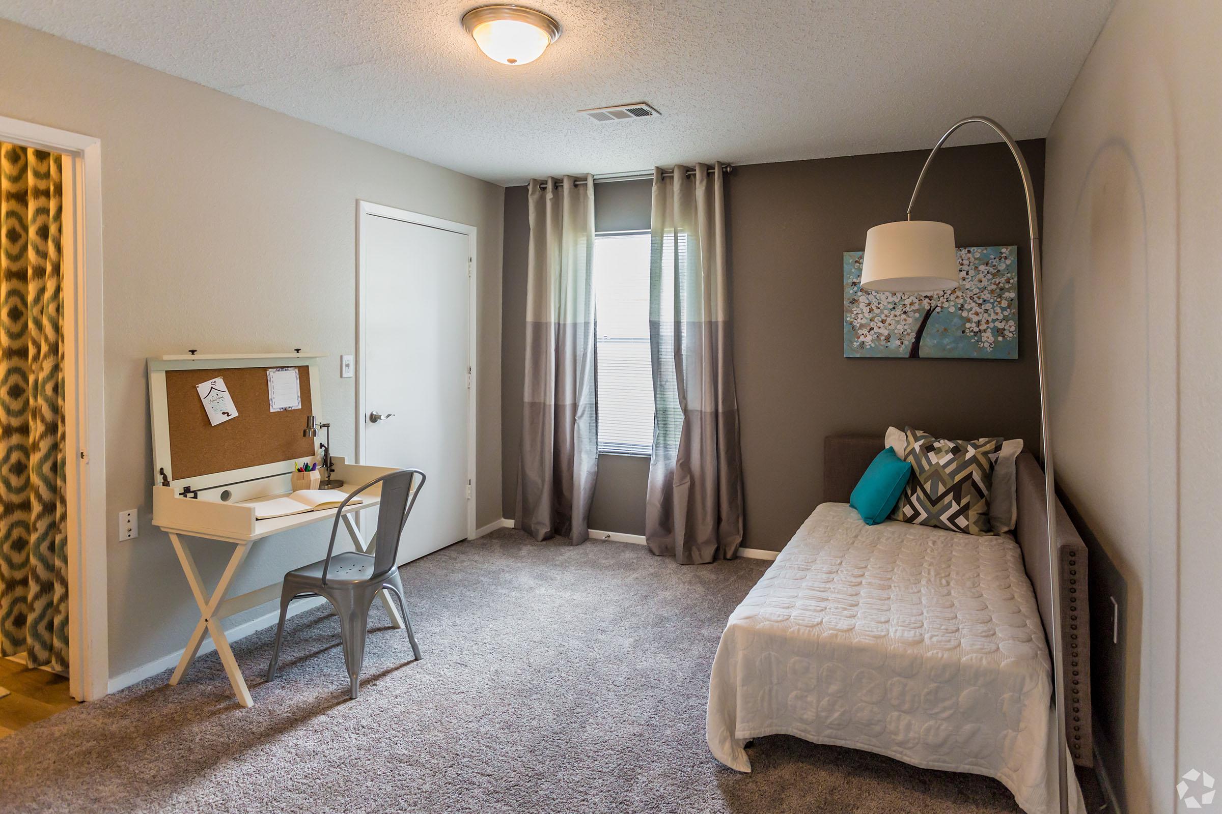 a bedroom with a bed and a chair in a room