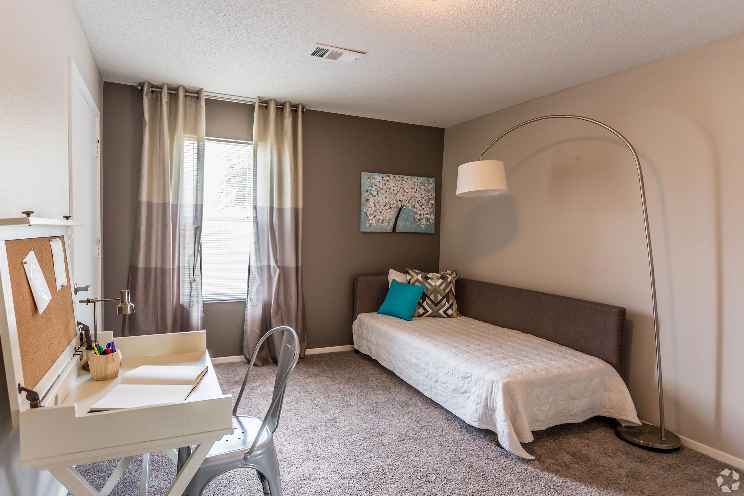 a bedroom with a bed and desk in a room