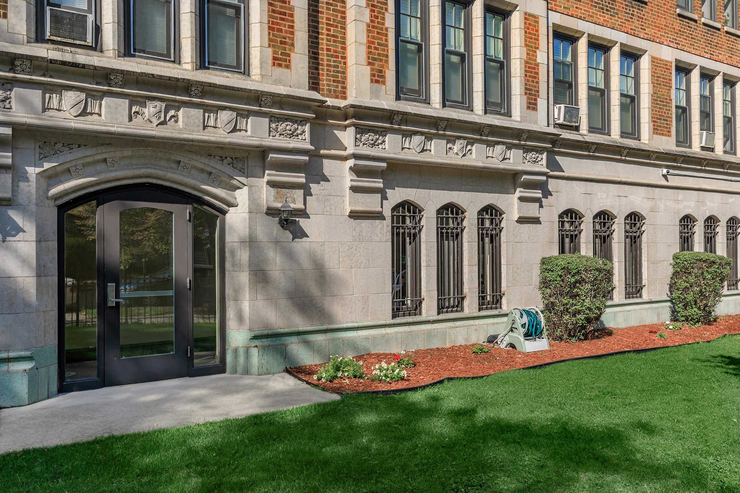 a large brick building with green grass