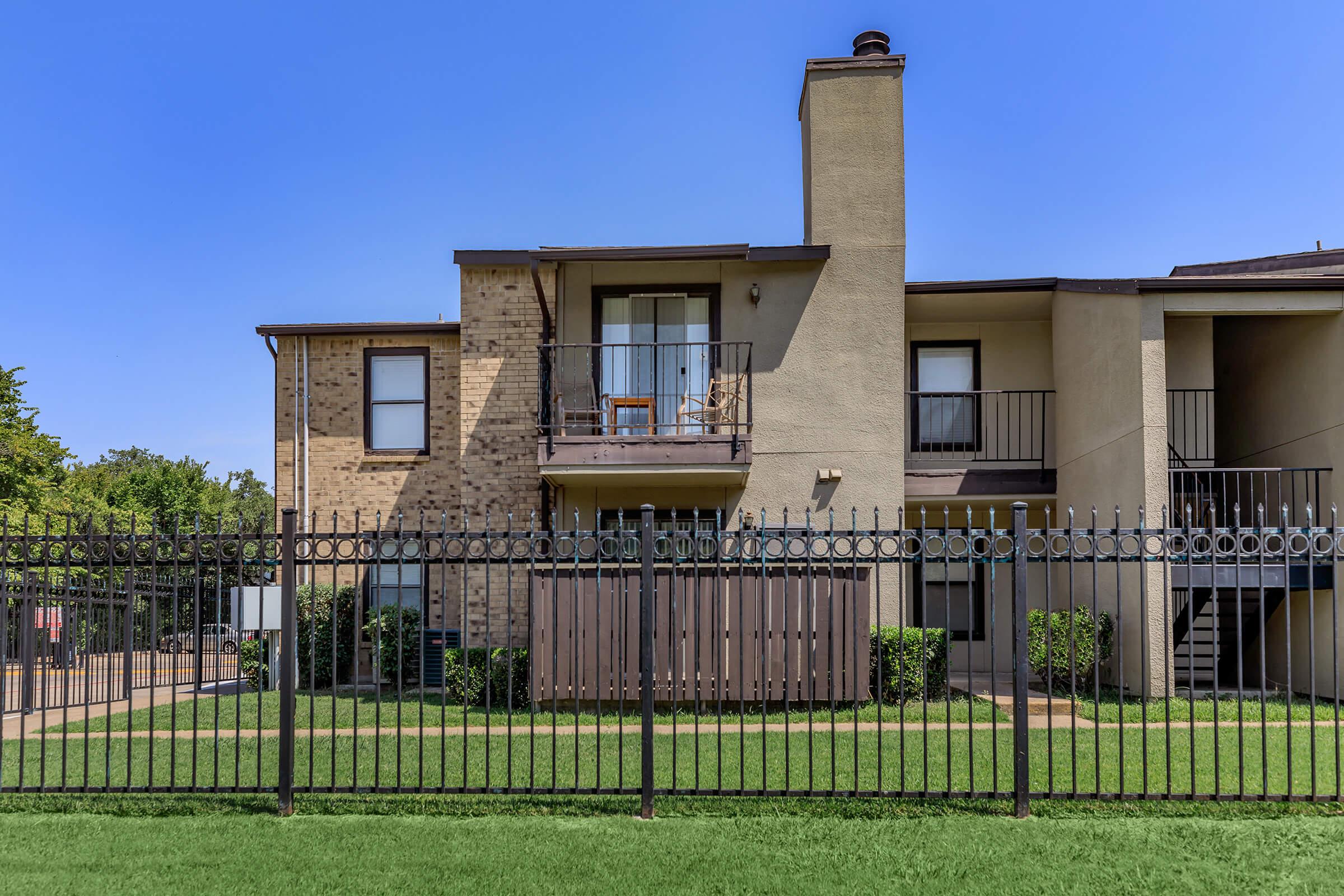 a house with a fence in front of a building