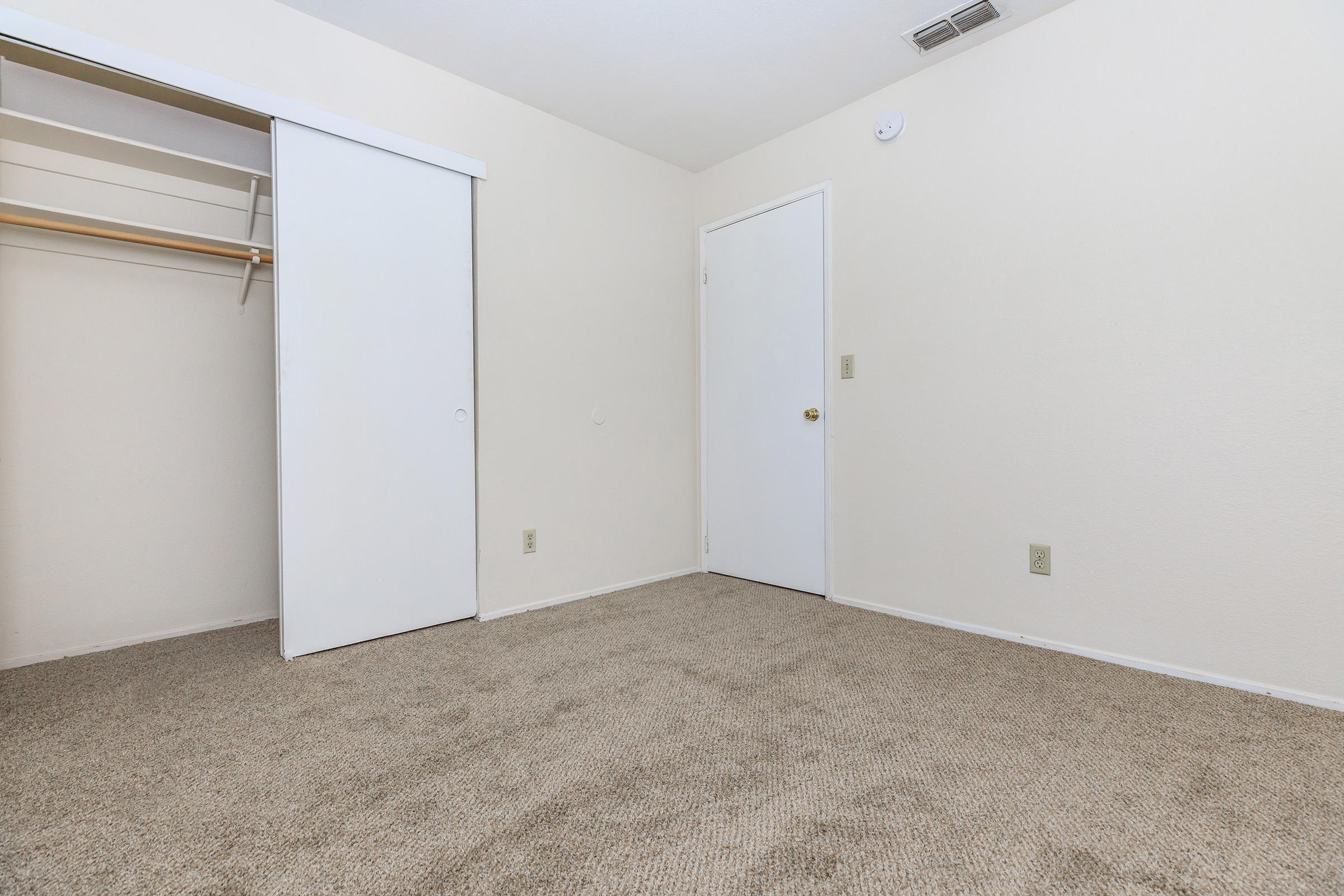 Carpeted bedroom with open sliding closet door