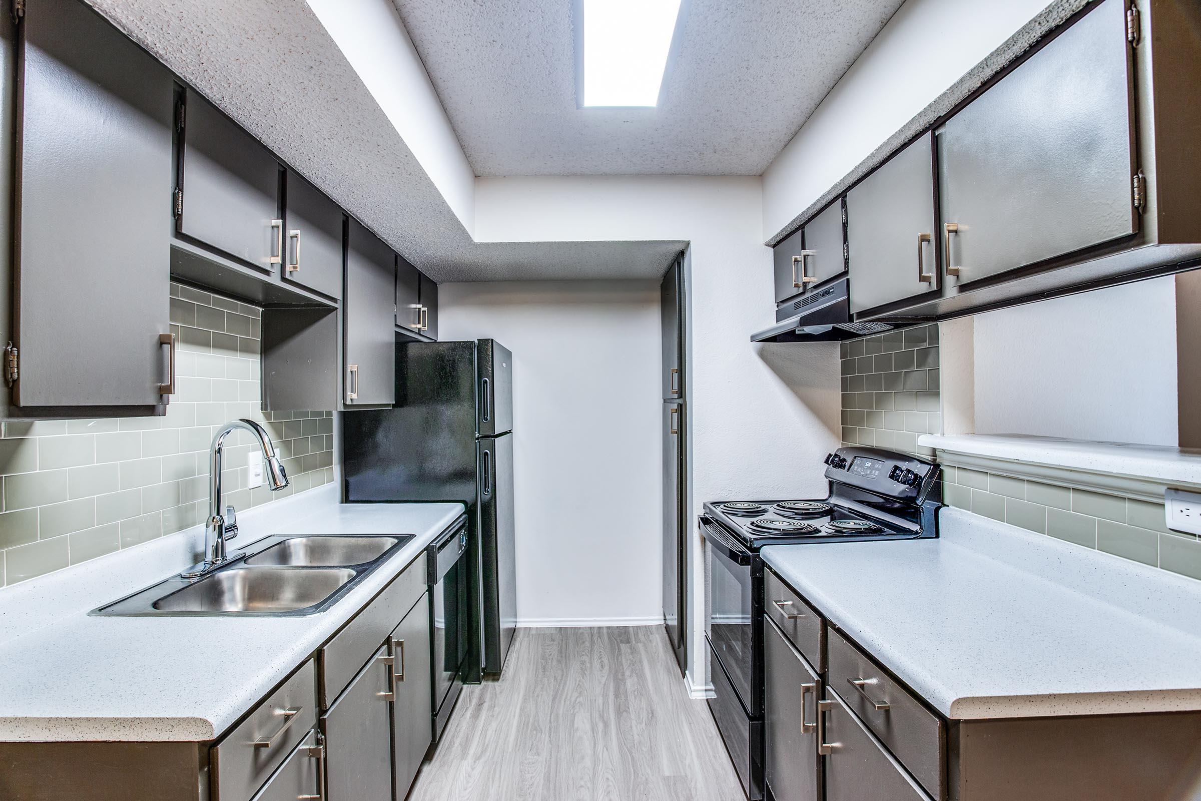 a kitchen with a sink and a mirror