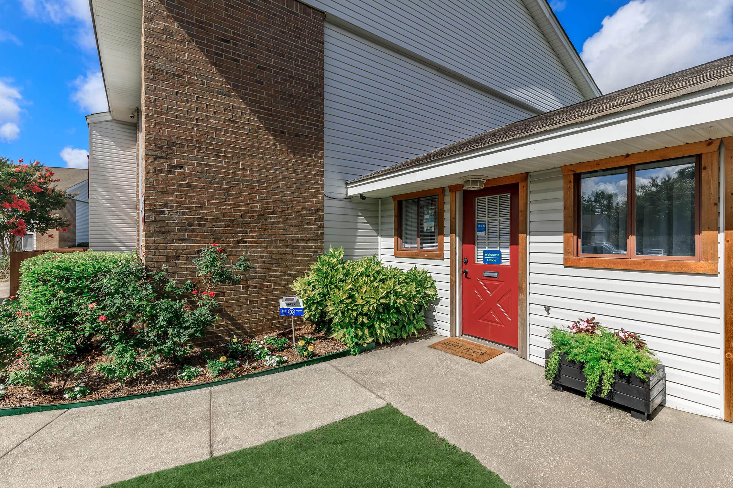 a garden in front of a brick building