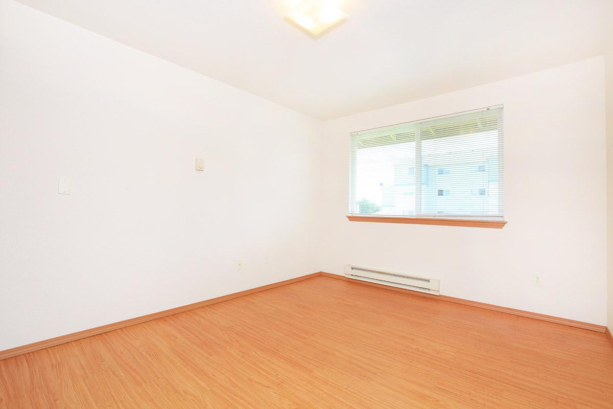 a bedroom with a wooden floor