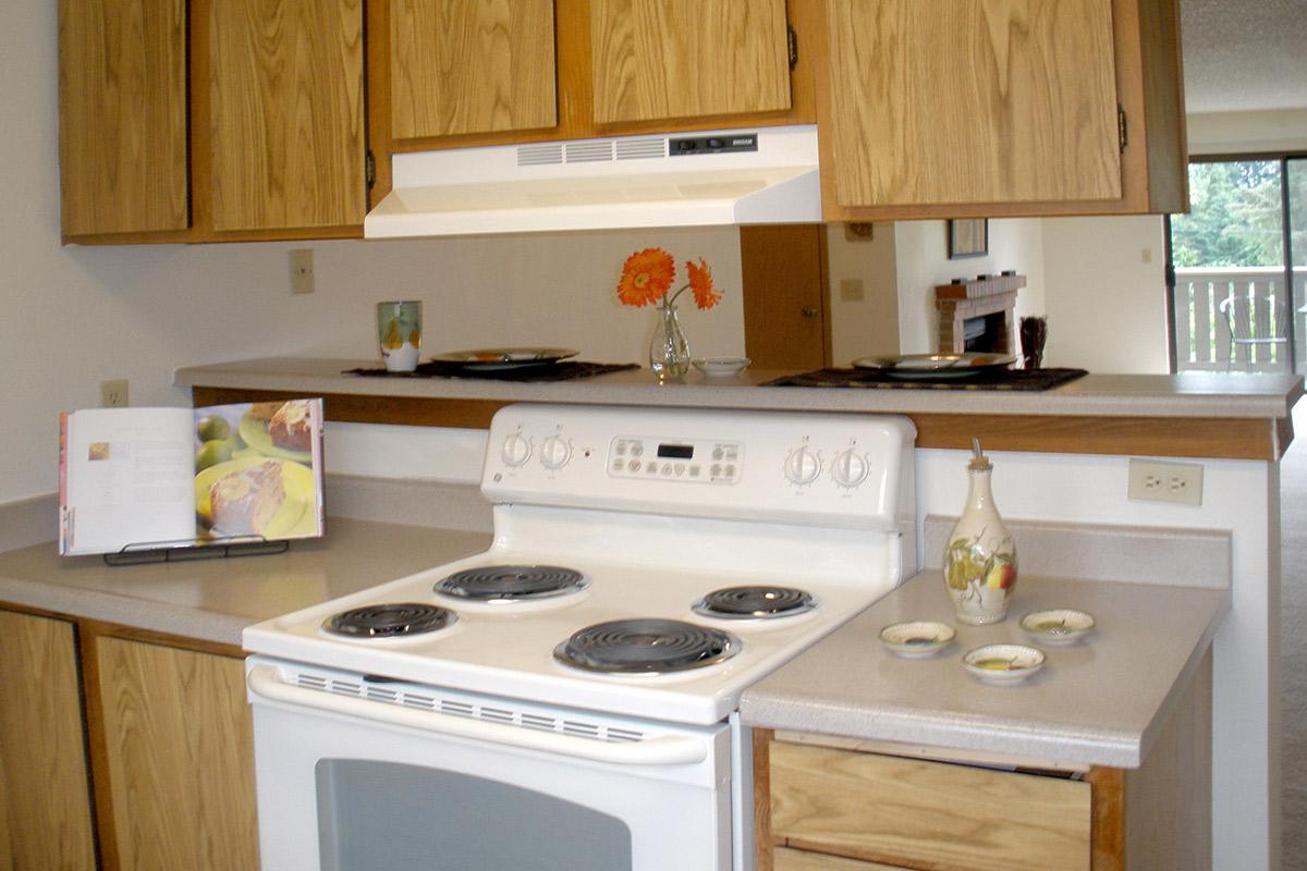 a white stove top oven sitting inside of a kitchen