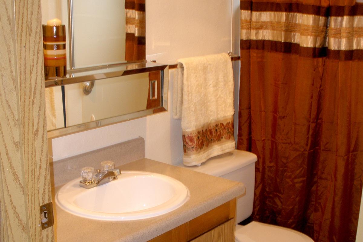 a white sink sitting next to a shower curtain