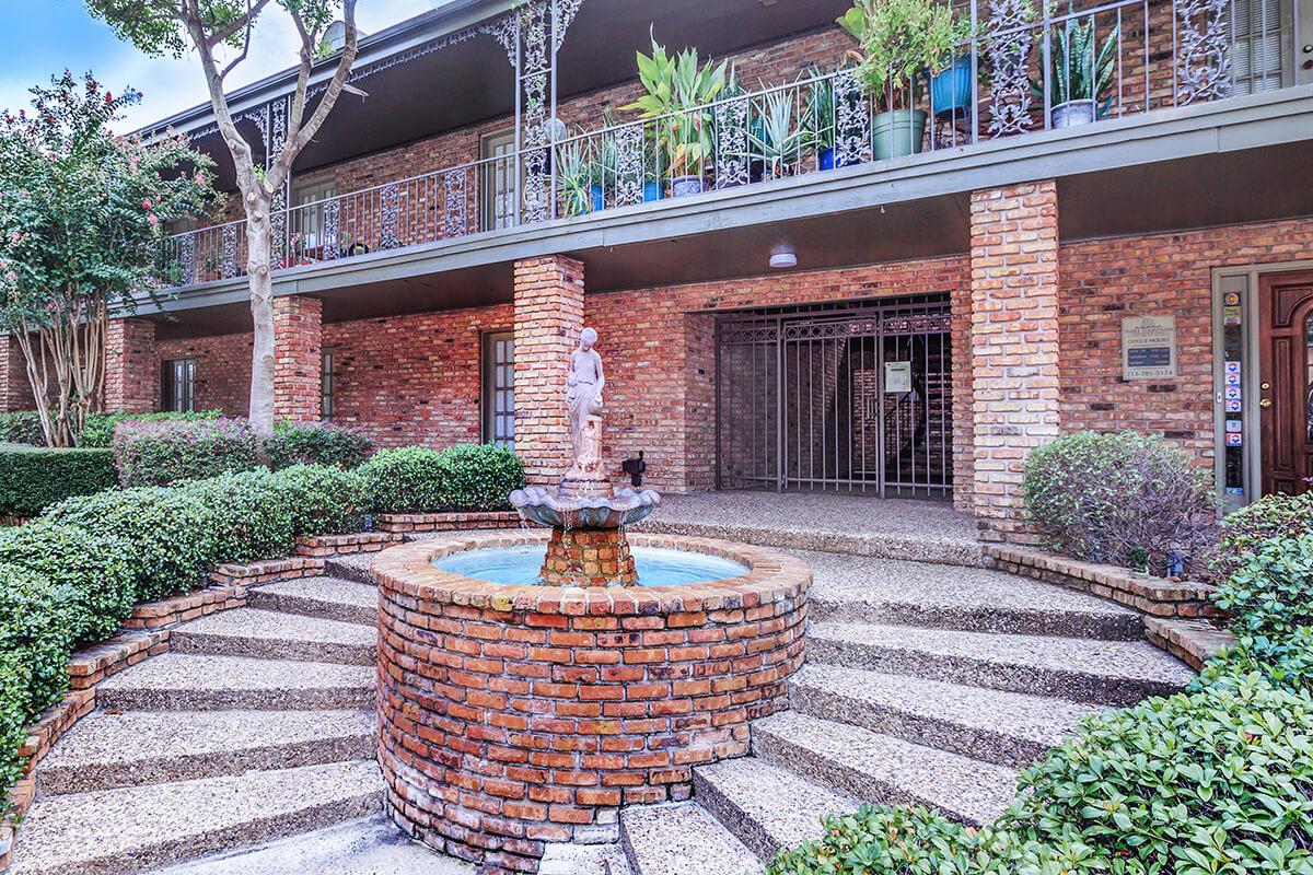 a garden in front of a brick building