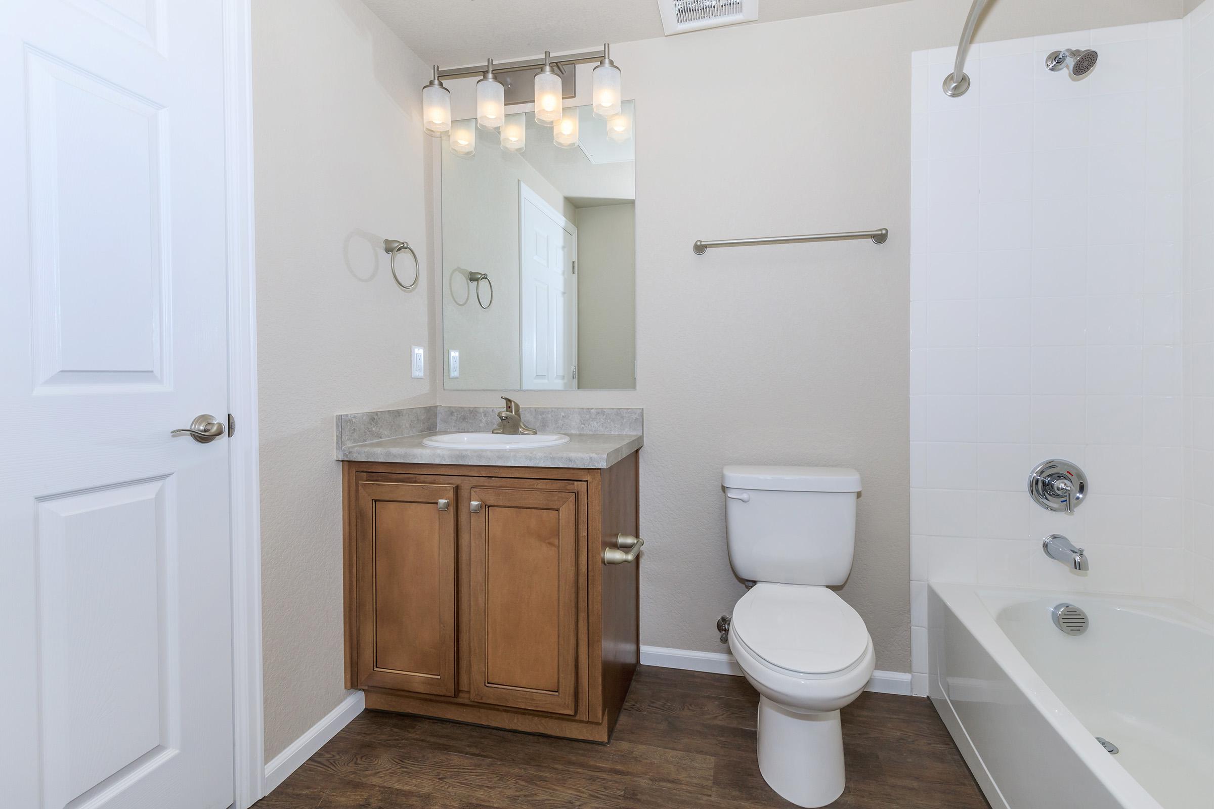 a white sink sitting under a mirror