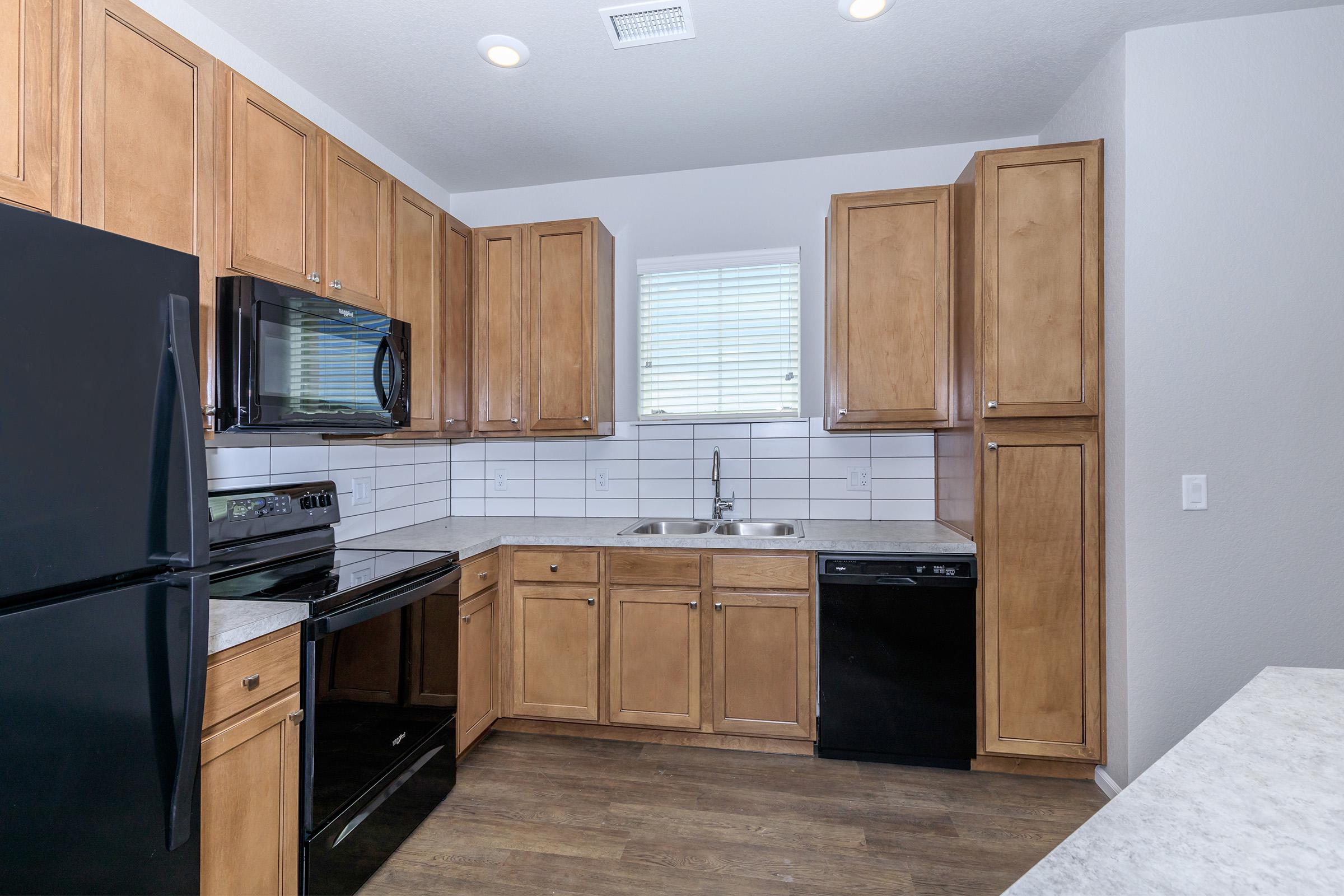 a kitchen with stainless steel appliances and wooden cabinets