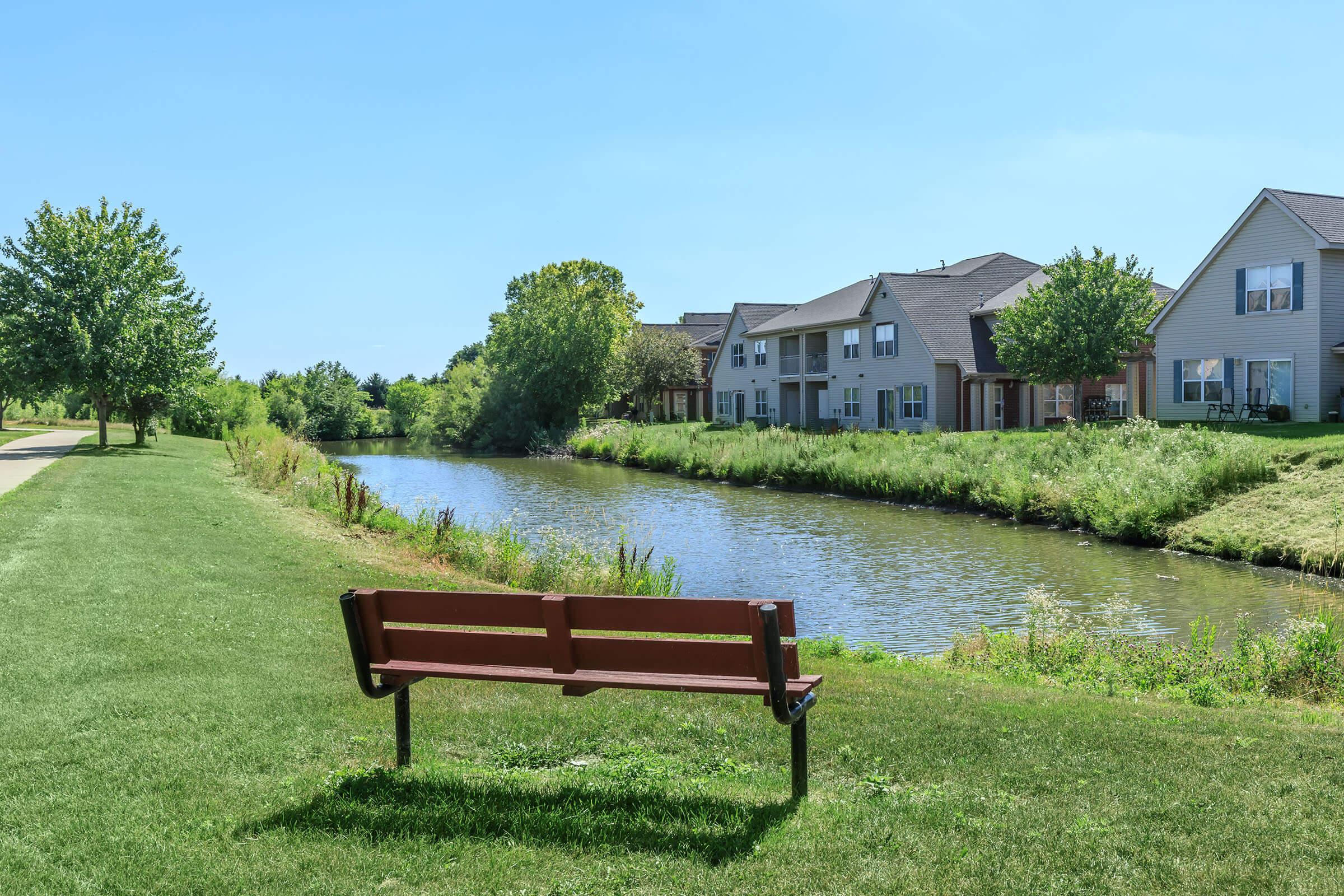 an empty park bench sitting in front of a house