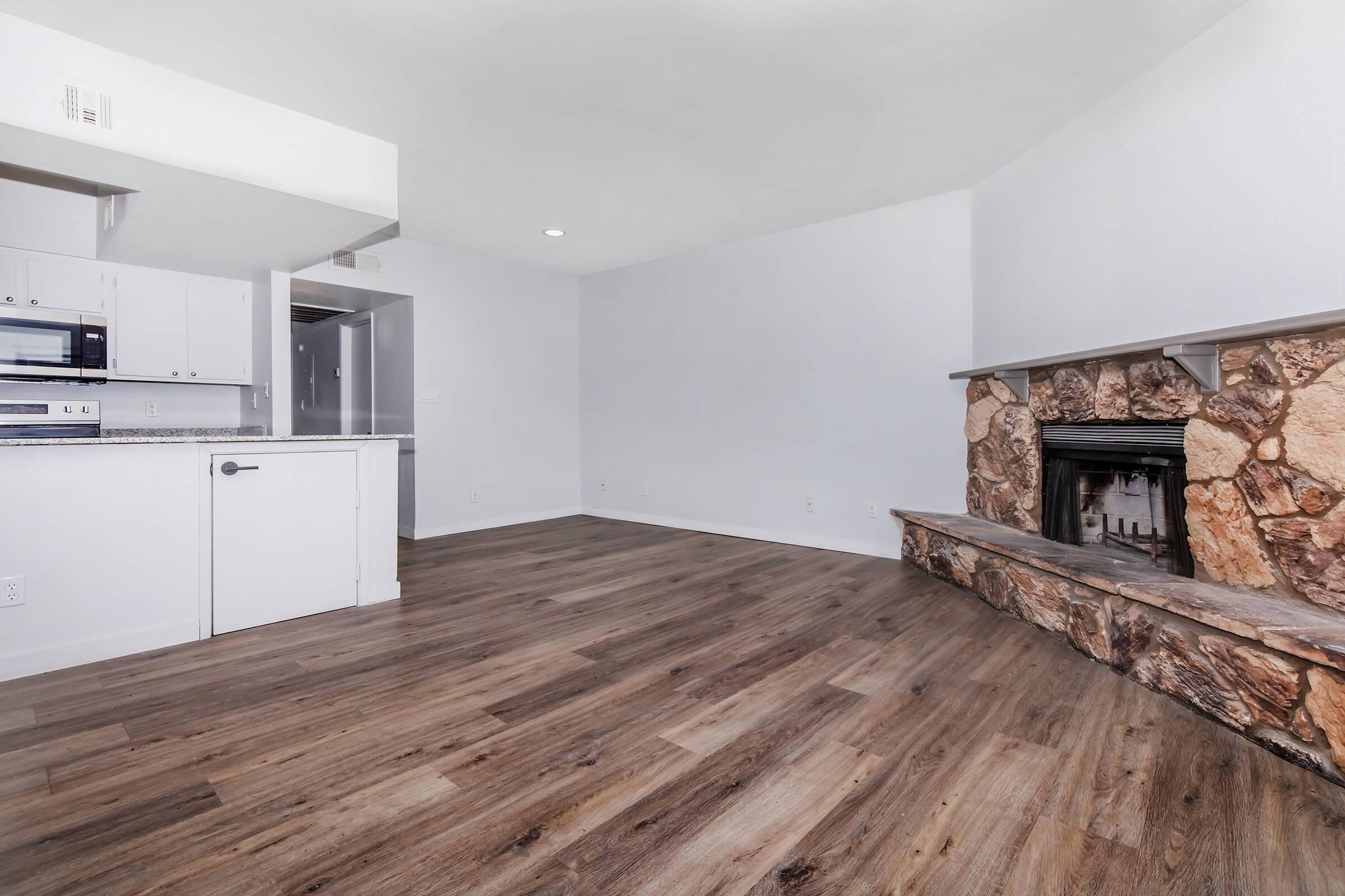 a kitchen with wooden cabinets and a wood floor