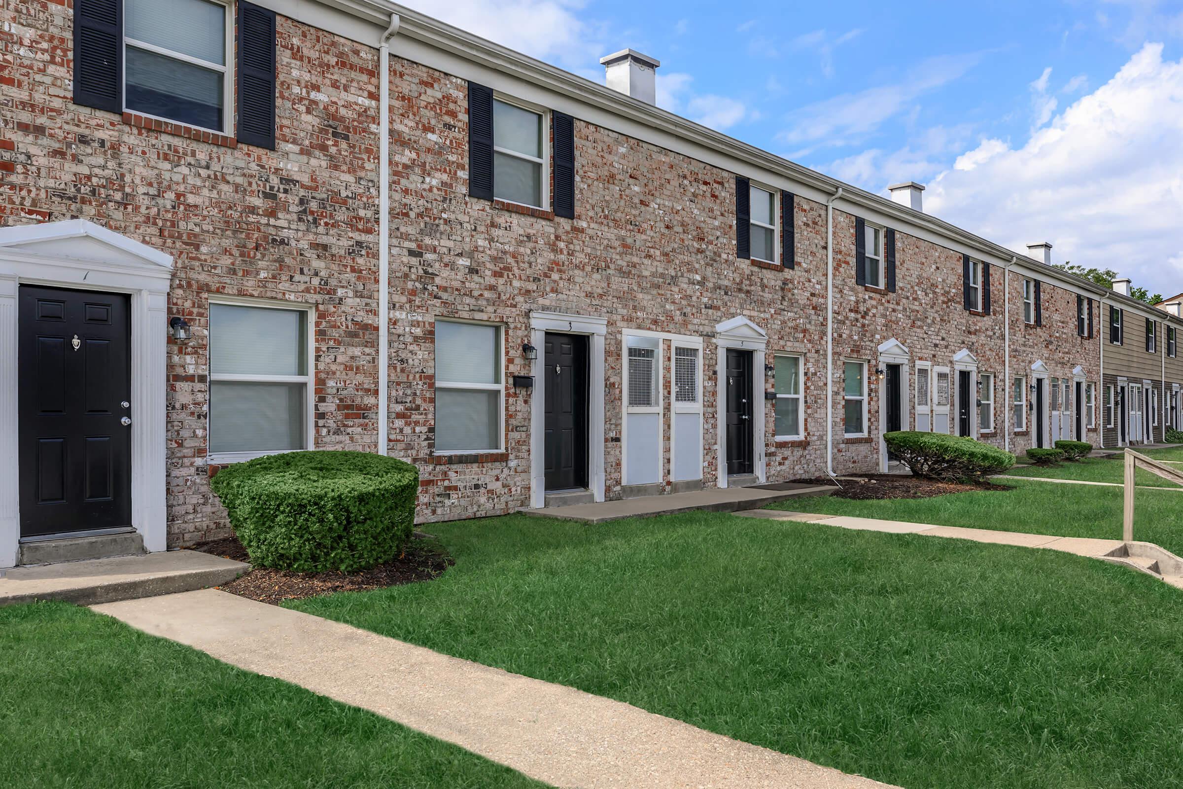 a large lawn in front of a brick building