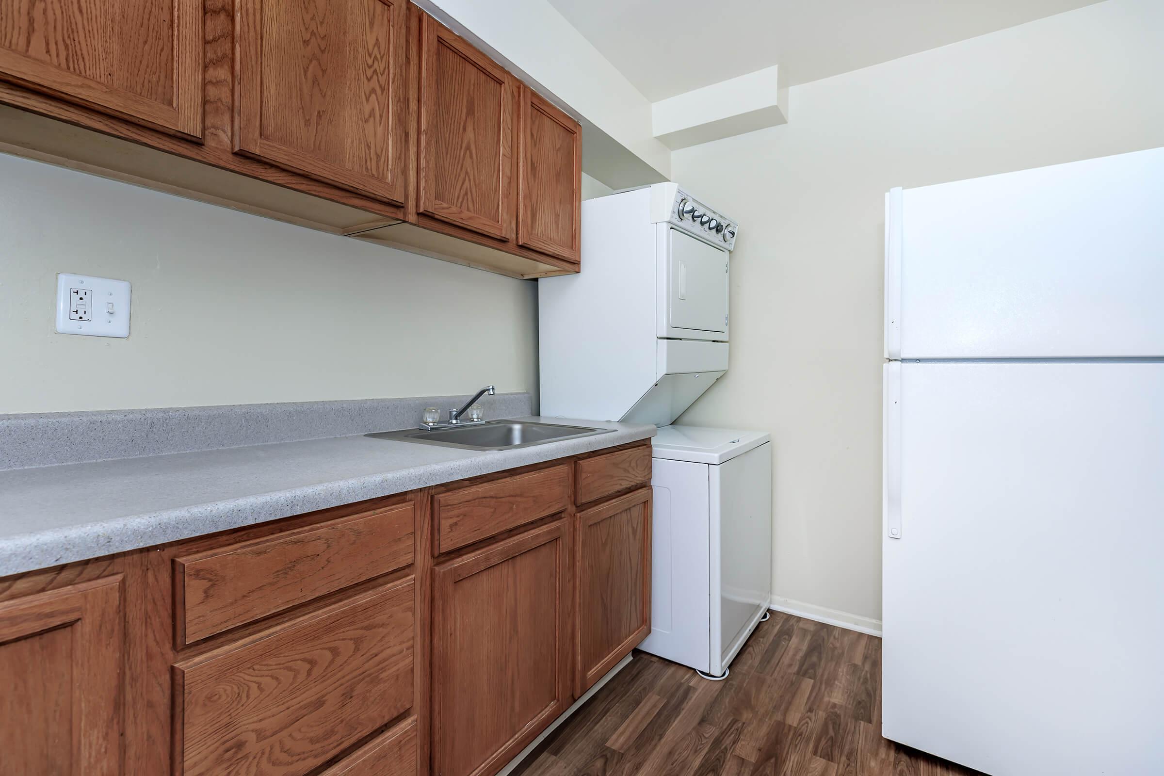 a kitchen with a stove refrigerator and wooden cabinets