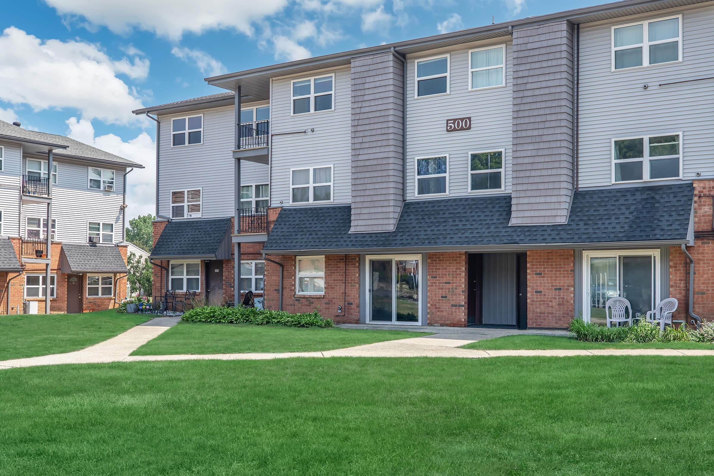 a large lawn in front of a brick building