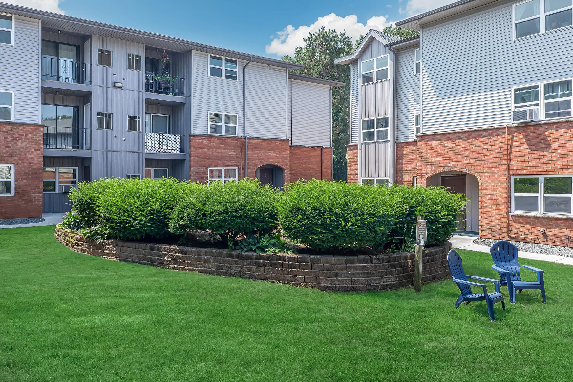 a house with a lawn in front of a brick building