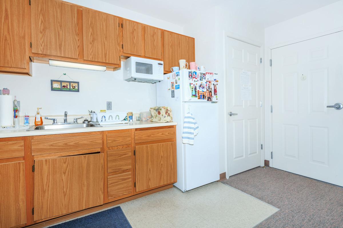 a kitchen with white appliances and wooden cabinets