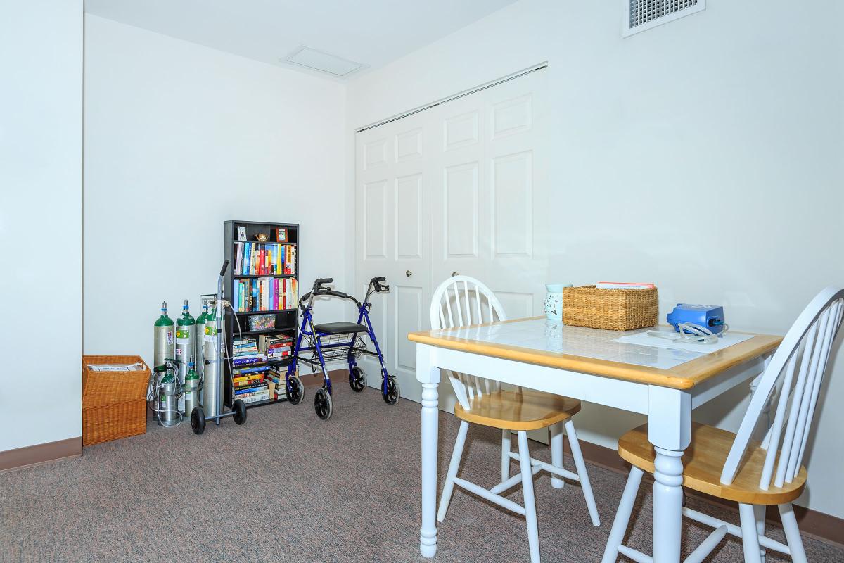 a kitchen with a table and a chair in a room