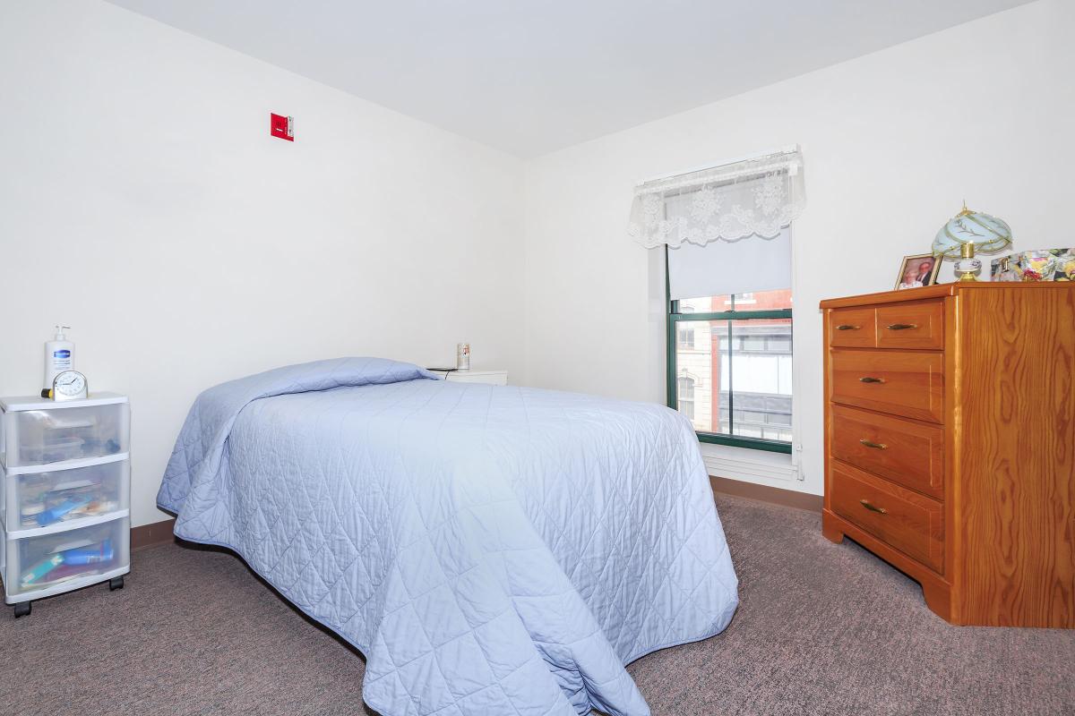 a bedroom with a bed and desk in a room