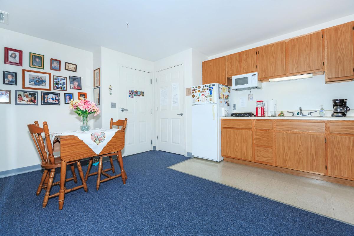 a room filled with furniture and a refrigerator in a kitchen