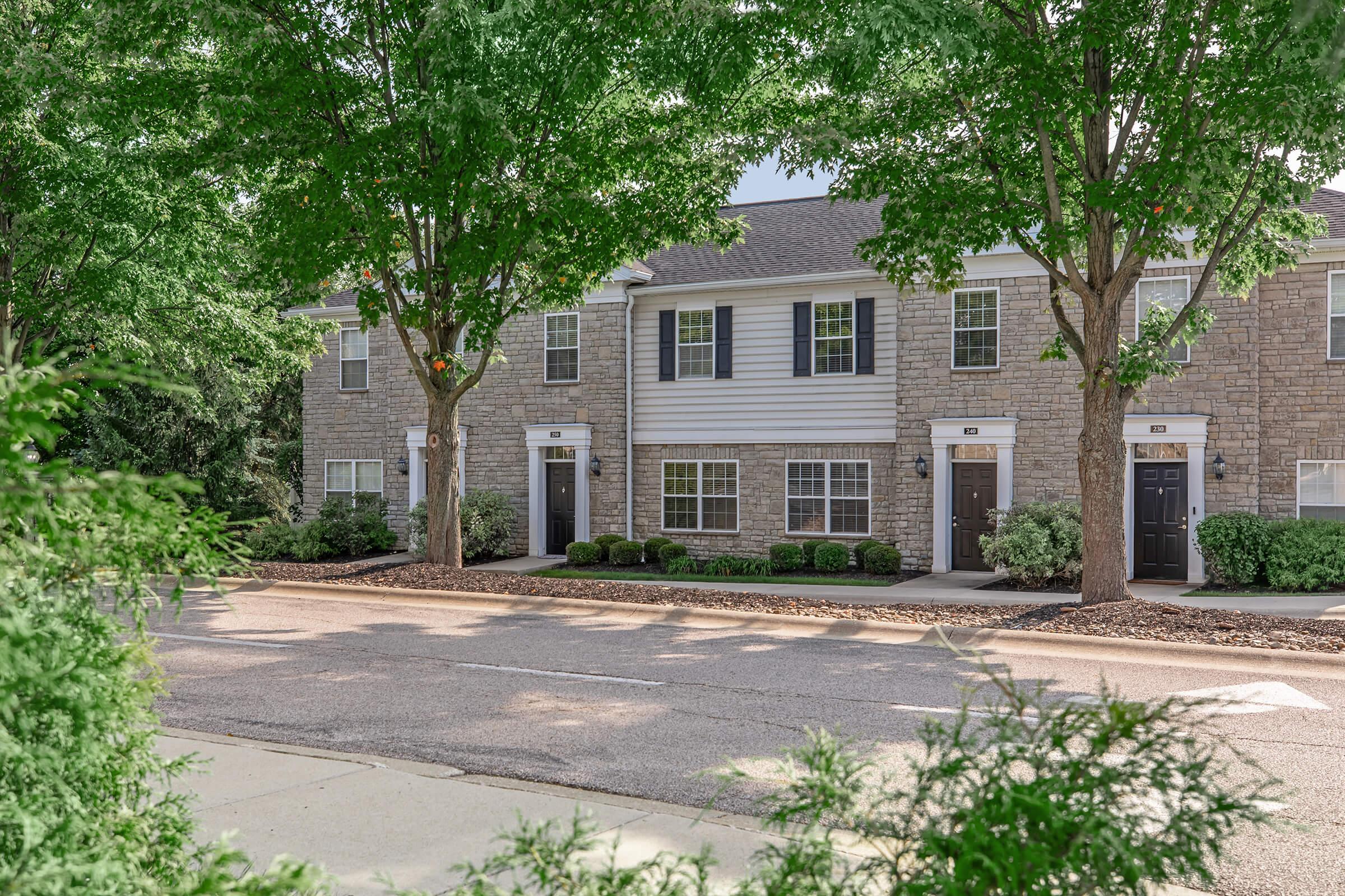 a house with bushes in front of a brick building