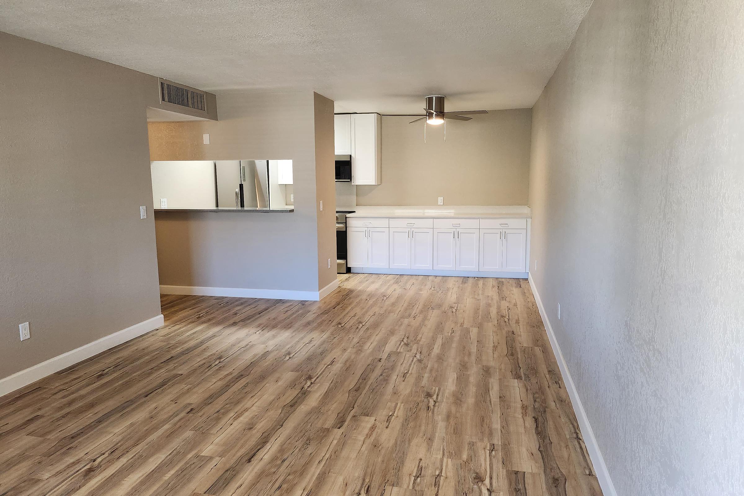 Living and dining area adjoining a kitchen with a breakfast bar.