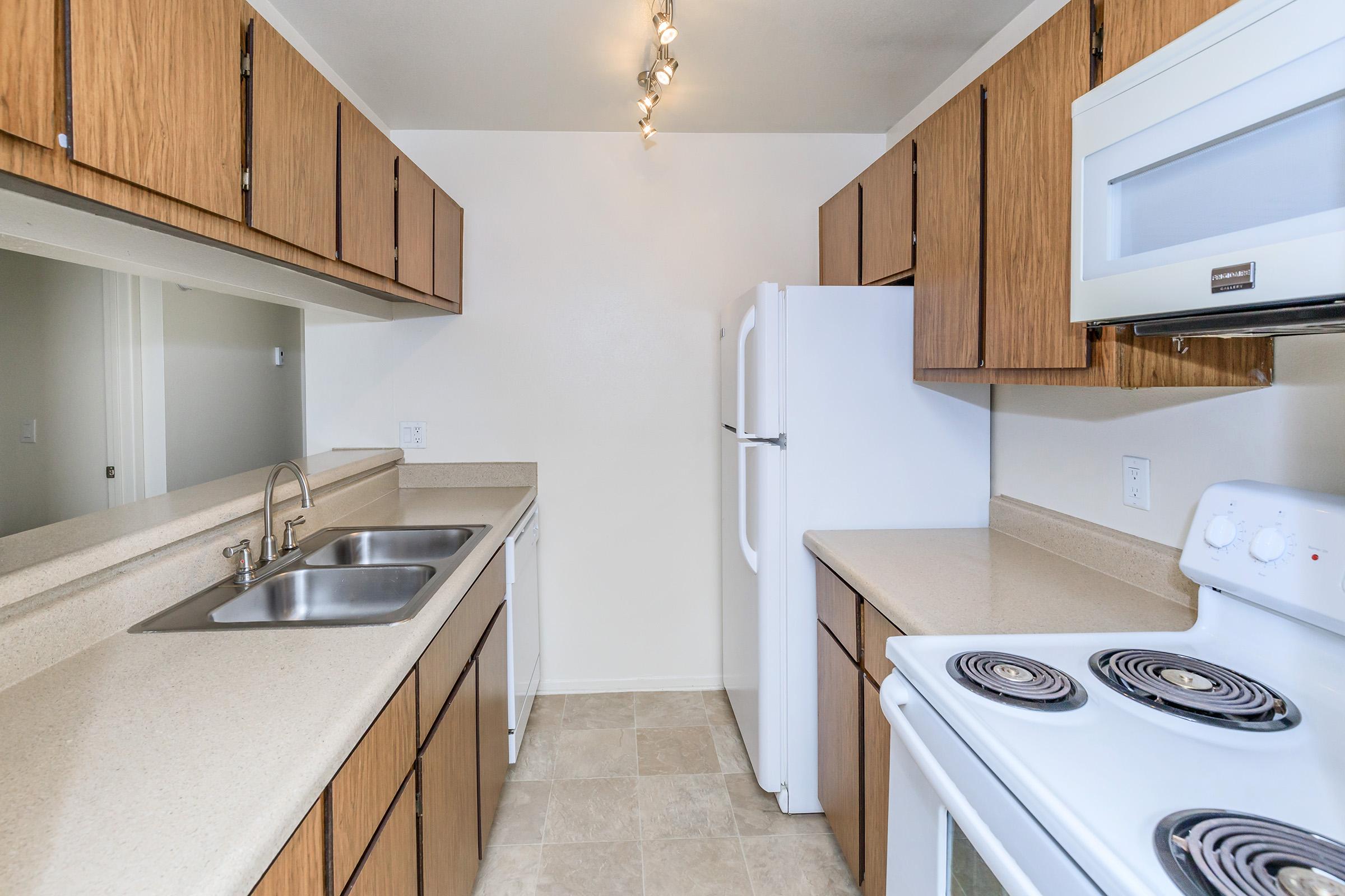 a kitchen with a stove sink and refrigerator