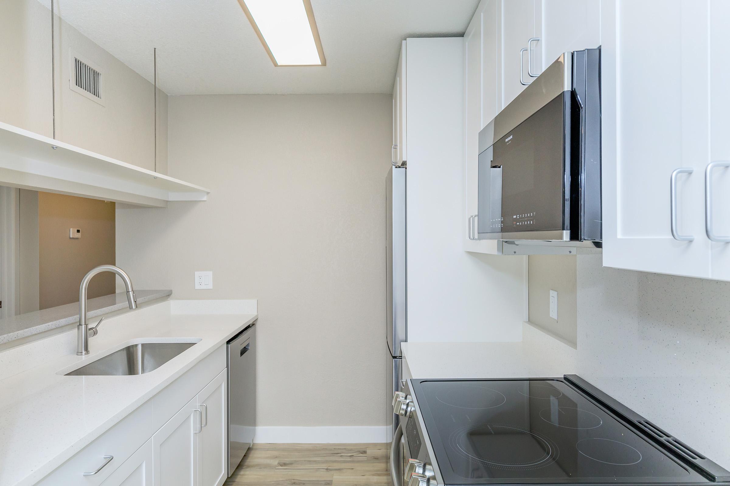 a kitchen with a sink and a mirror