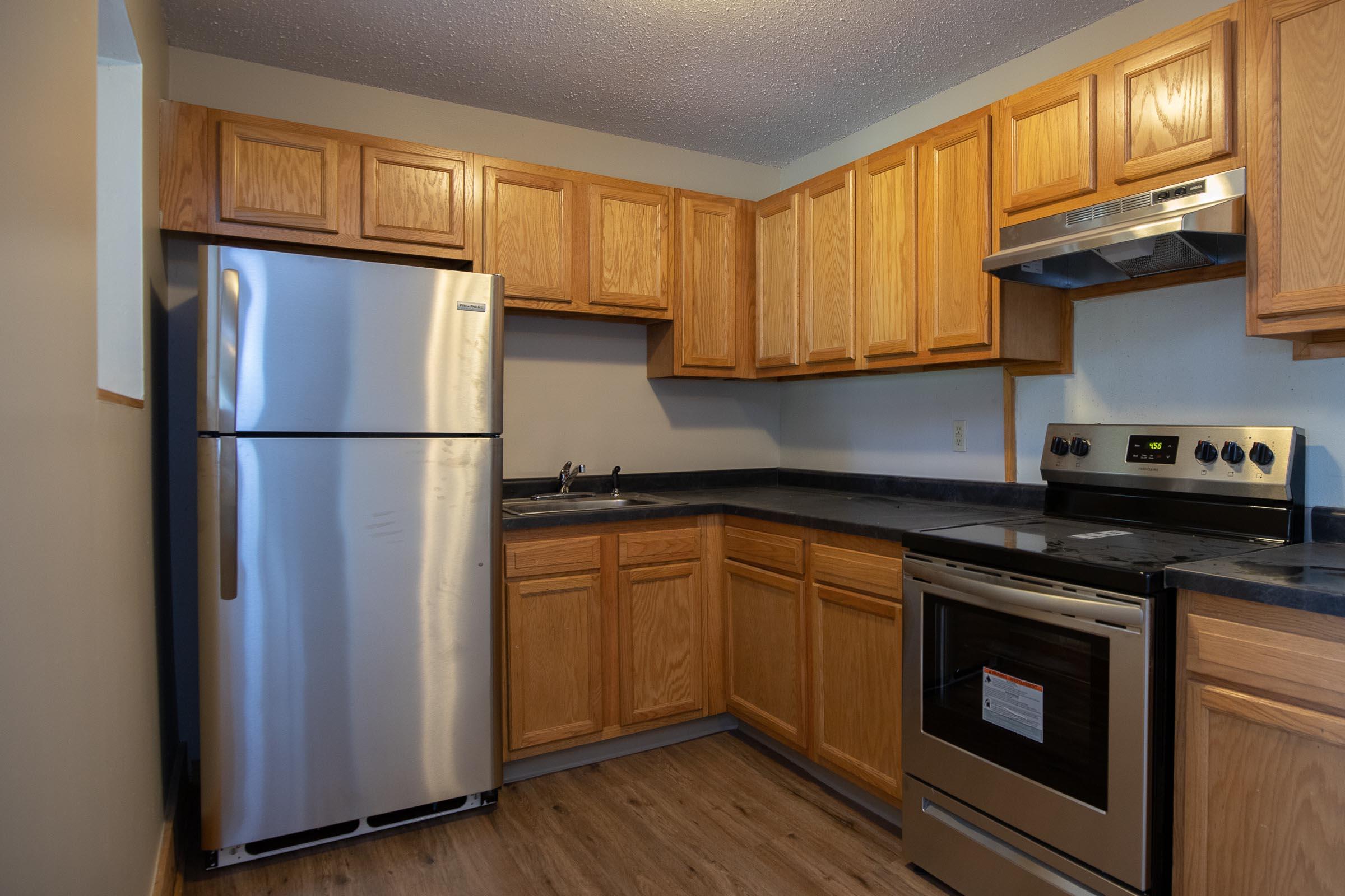 a kitchen with stainless steel appliances and wooden cabinets