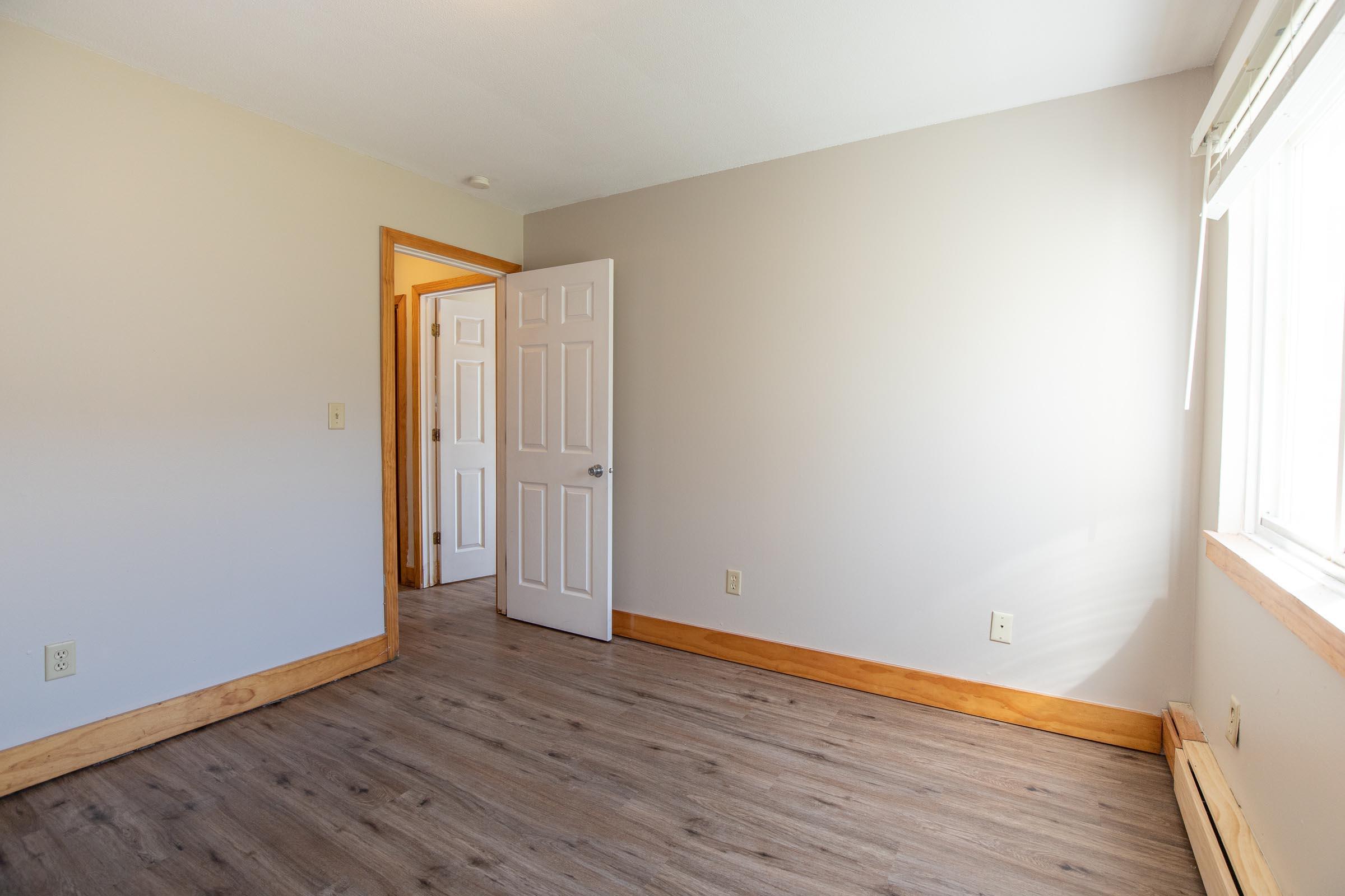 a bedroom with a wooden floor