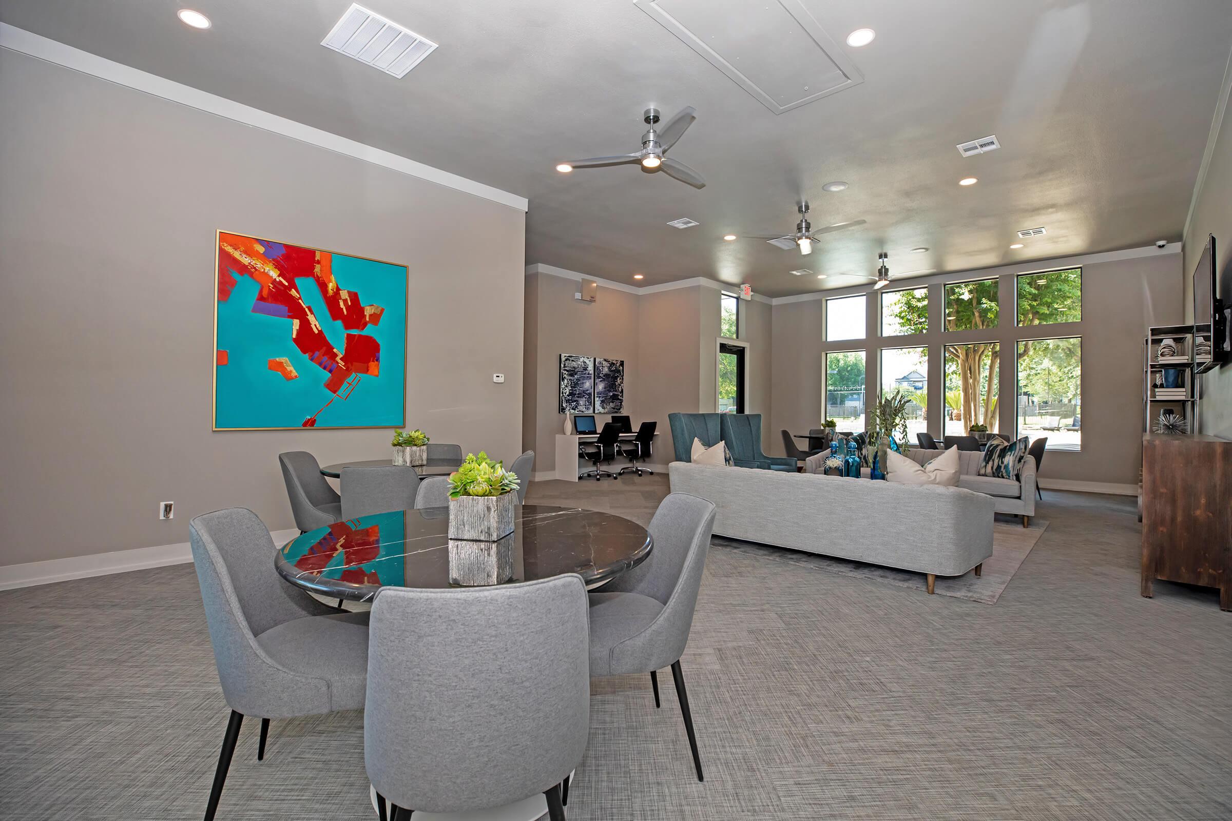 The Falls Round Rock Apartments community room with grey chairs